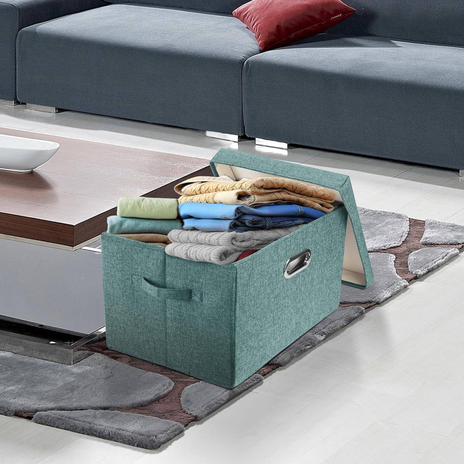 Aufbewahrungsbox aus Stoff mit ordentlich zusammengelegten Kleidungsstücken neben einem modernen grauen und hölzernen Couchtisch in einer zeitgenössischen Wohnzimmereinrichtung.