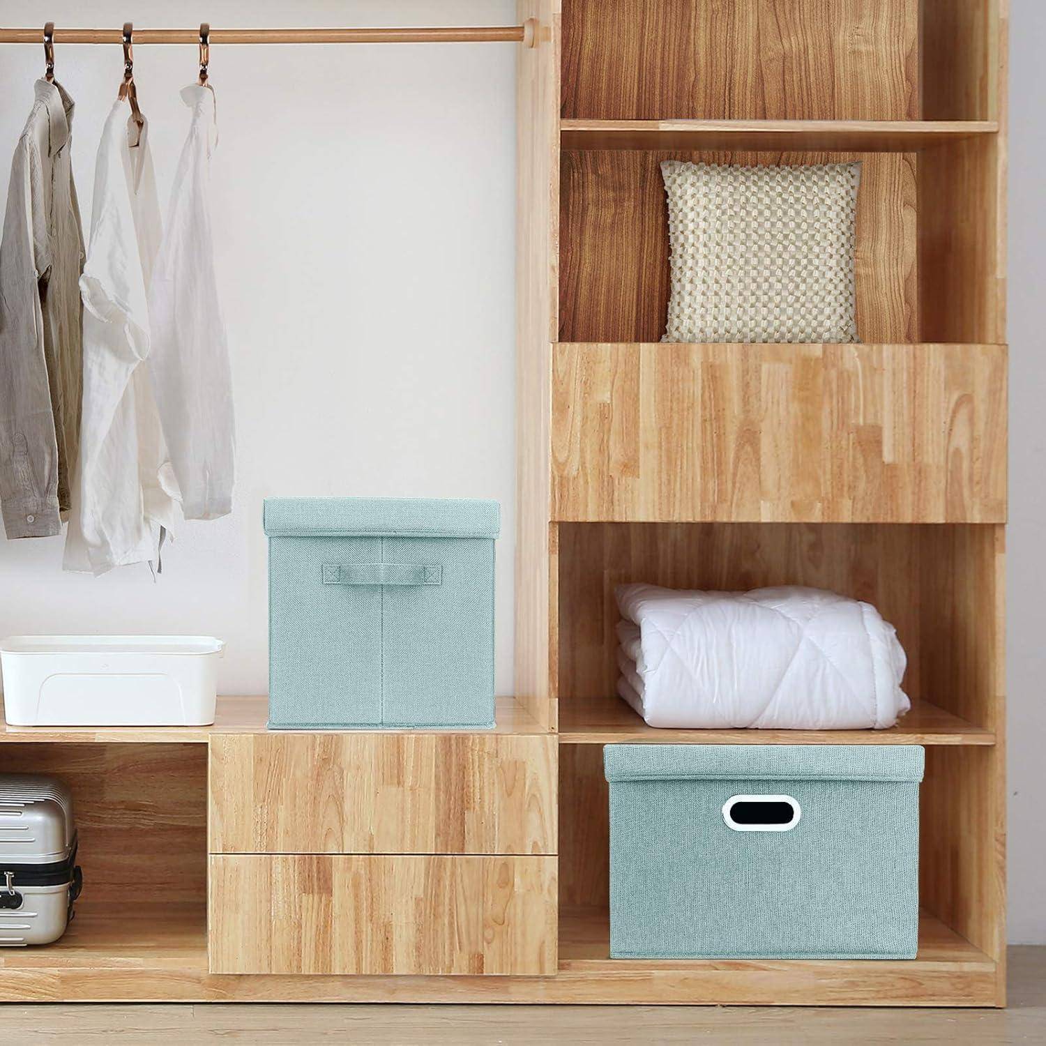 Holzschrank mit hängenden Kleidungsstücken, geflochtener Korb, gefalteten Bettwäschestücken und zwei türkisfarbenen Aufbewahrungsboxen. Einfache und organisierte Aufbewahrungslösung.