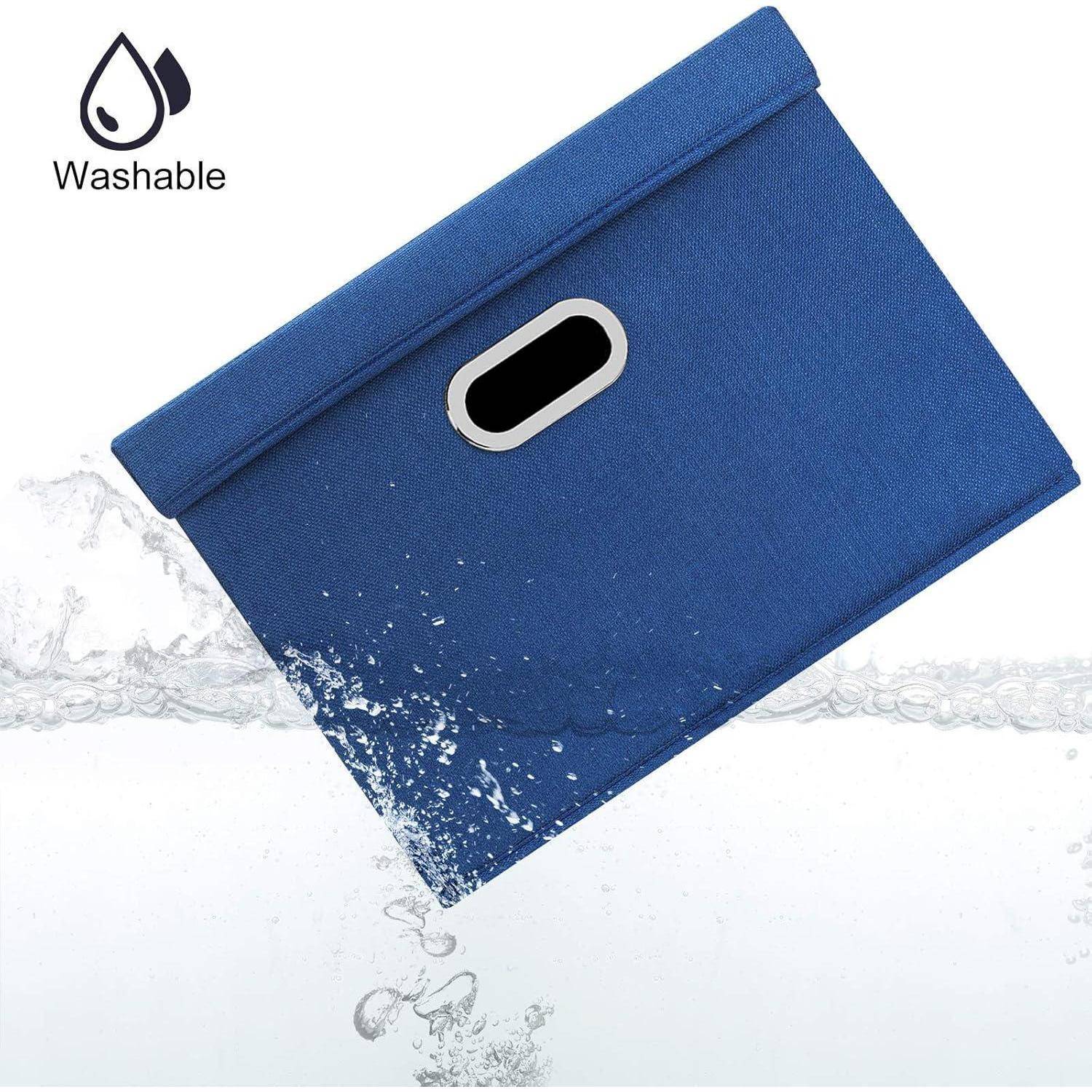 Blaue Aufbewahrungsbox aus Stoff mit Griff, mit dem Etikett 'Waschbar', präsentiert mit Wasserspritzereffekt, der andeutet, dass sie wasserfreundlich ist.