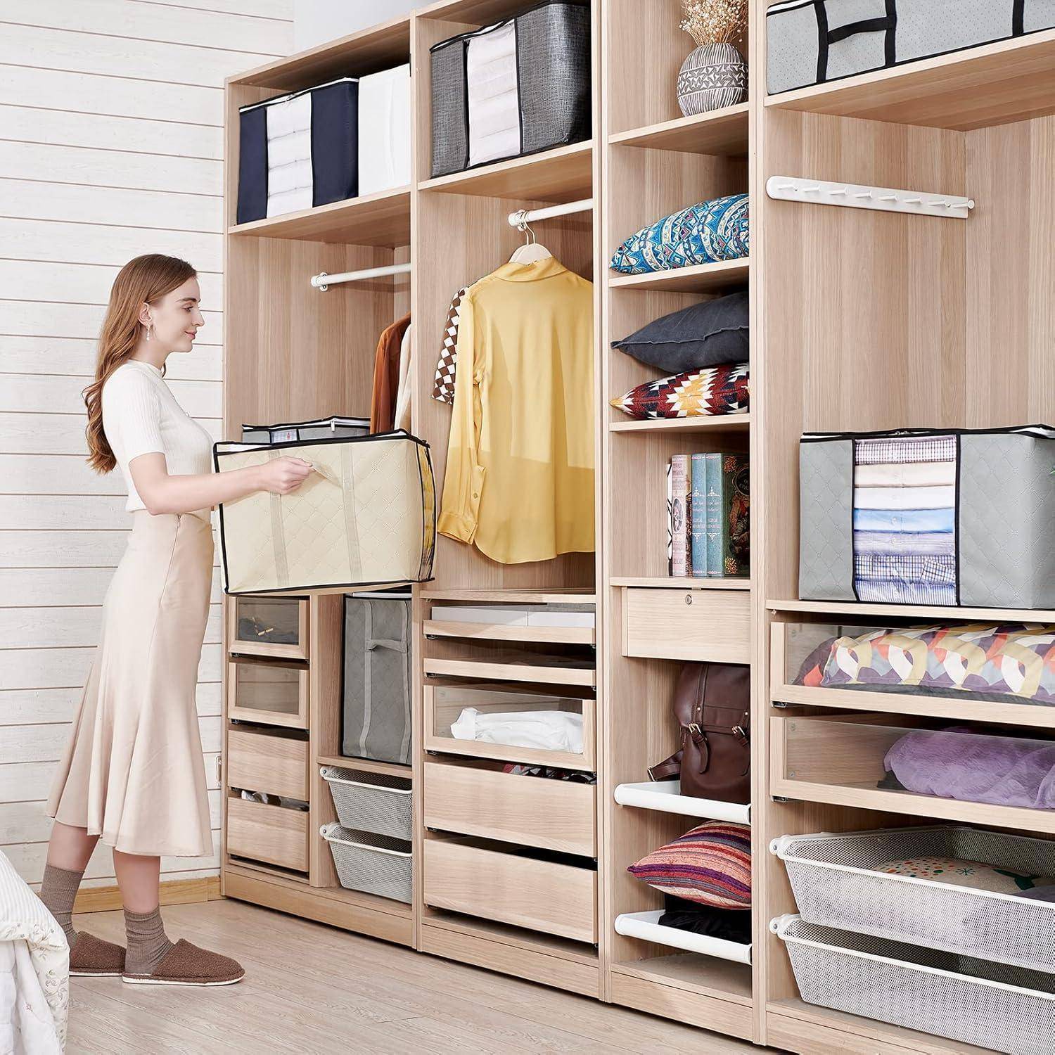 Eine Frau organisiert einen Holzkleiderschrank mit Stoffkörben und Regalen. Kleidungsstücke und Accessoires sind ordentlich angeordnet und deuten auf eine aufgeräumte Aufbewahrung hin.