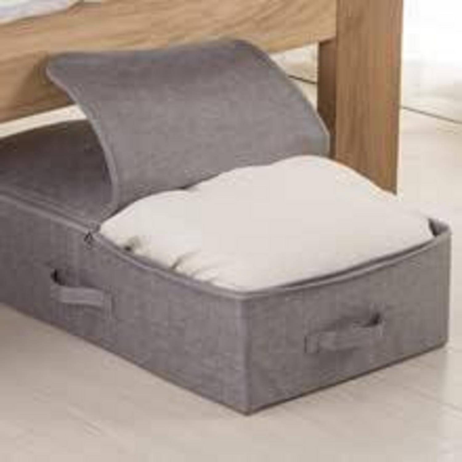 Eine graue Aufbewahrungsbox unter einem Bett ist geöffnet und zeigt Bettwäsche im Inneren, was eine organisierte und platzsparende Aufbewahrung zu Hause symbolisiert.