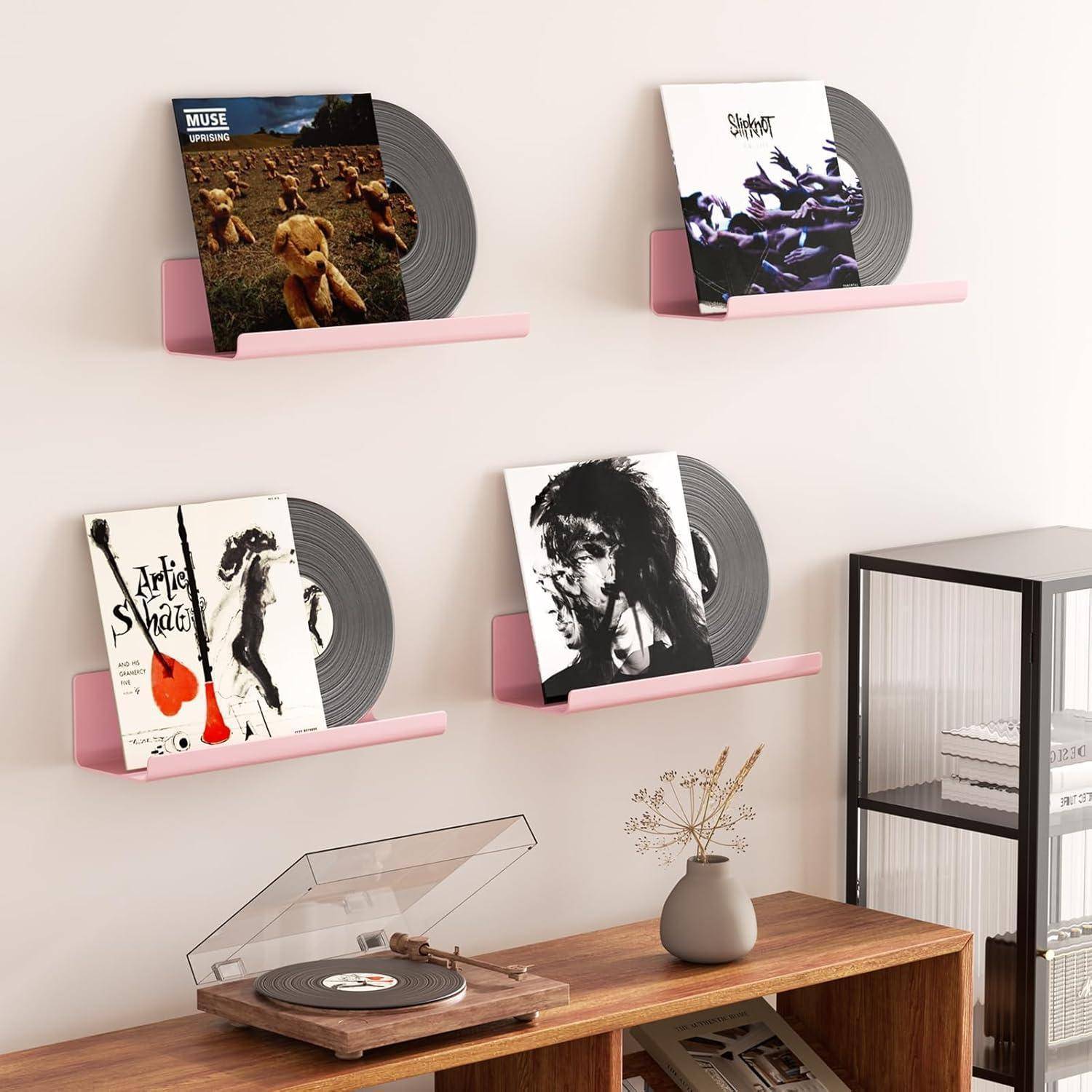 Ein Raum mit einem Plattenspieler, Schallplatten an Wandregalen und einer kleinen Pflanze. Jedes Regal trägt eine Schallplatte mit unverwechselbarem Albumcover.