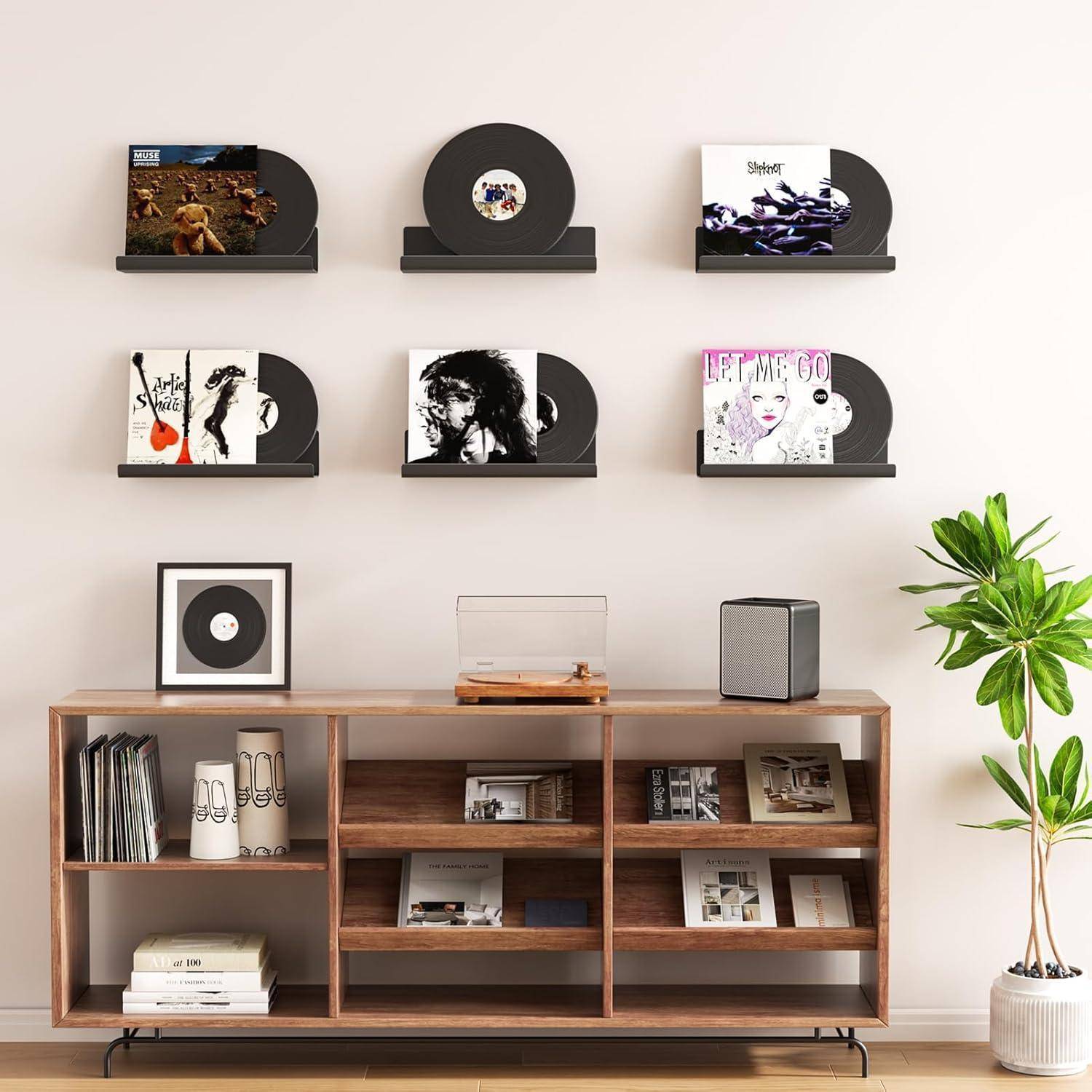 Ein modernes Wohnzimmer mit einem Holzregal, das Schallplatten und Bücher präsentiert, dekoriert mit einer Topfpflanze und an der Wand montierten Plattenauslagen.