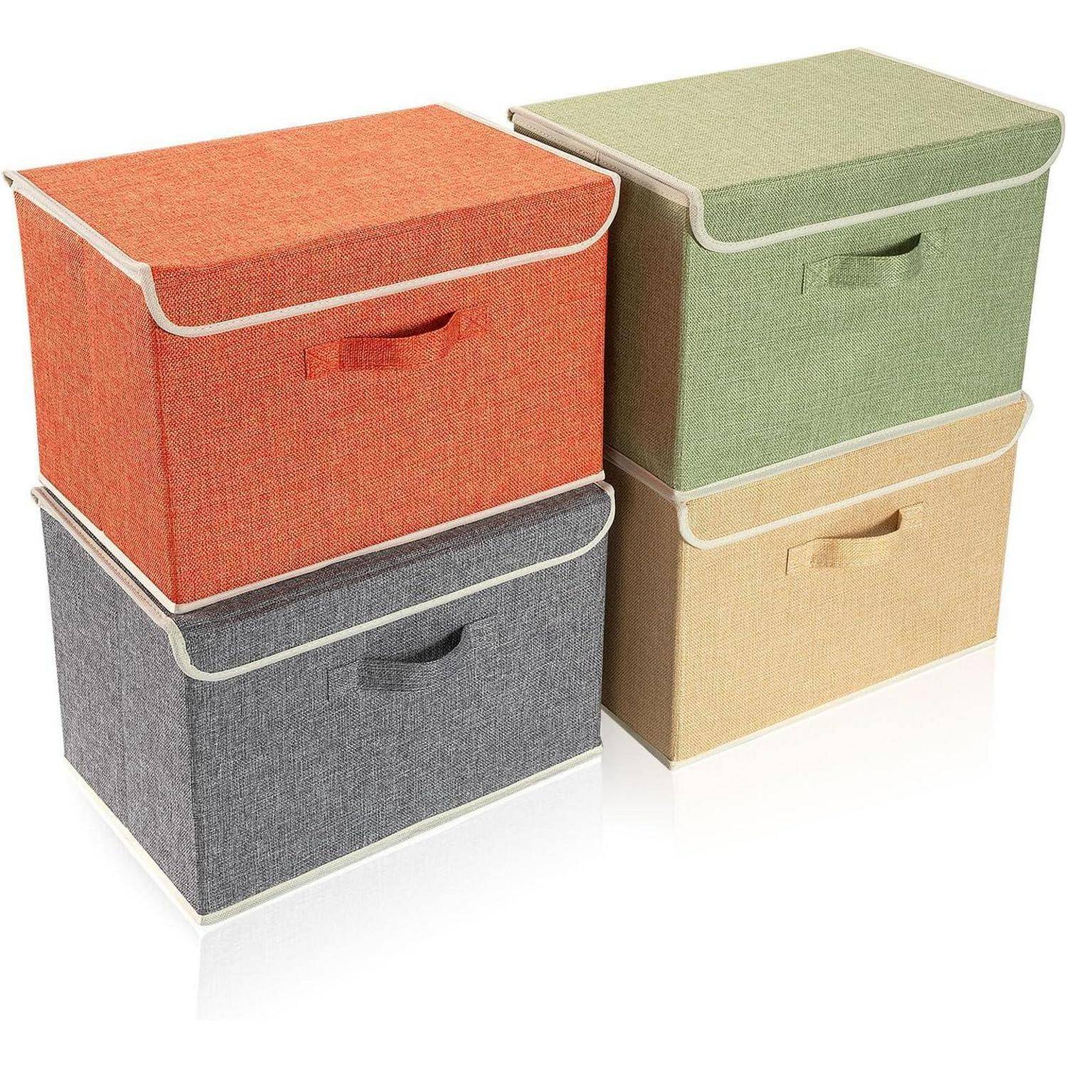Vier Aufbewahrungsboxen aus Stoff in Orange, Grün, Grau und Beige sind in zwei Reihen gestapelt, jede mit einem Deckel und weißer Einfassung.