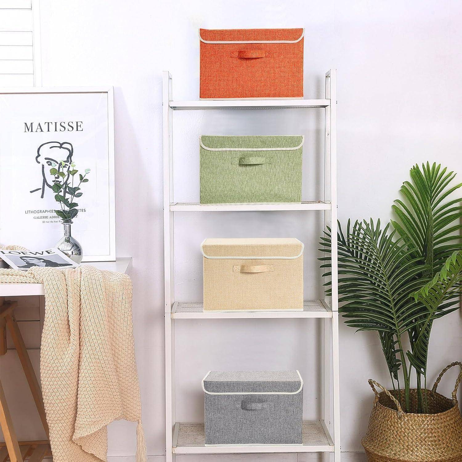 Ein ordentliches weißes Regal trägt Aufbewahrungsboxen in Orange, Grün, Beige und Grau. Eine nahegelegene Pflanze und ein gerahmter Matisse-Druck ergänzen die Dekoration.
