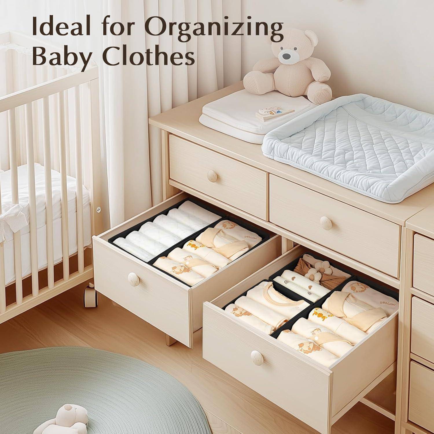 Ein Kinderzimmer mit einer offenen Kommode, auf der ordentlich sortierte Babykleidung in zwei Schubladen zu sehen ist, daneben eine Wickelauflage und ein Teddybär oben drauf.