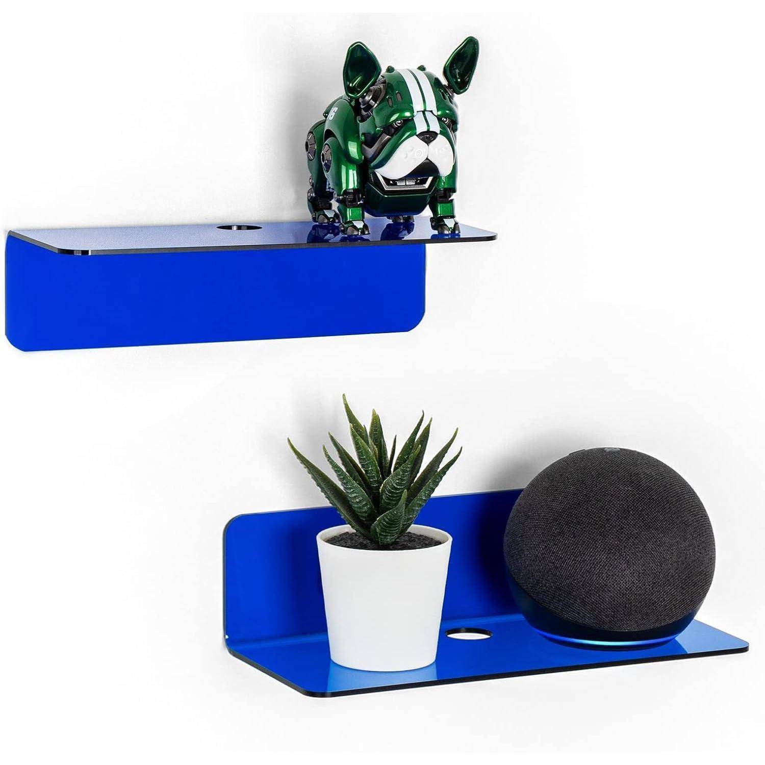 Eine dekorative Anordnung mit zwei blauen Wandregalen; das obere Regal trägt eine kleine Figur, die einem Hund ähnelt, und das untere Regal trägt eine Topfpflanze und einen kugelförmigen Lautsprecher.