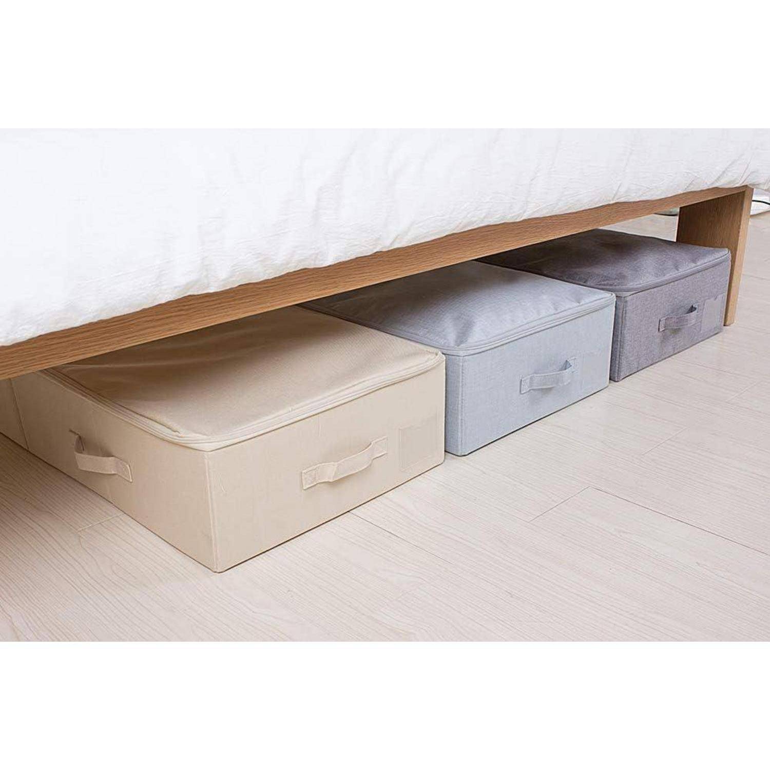 Unterbett-Aufbewahrung mit drei rechteckigen Stoffboxen in Beige, Grau und Dunkelgrau, ordentlich unter einem Holzbettgestell platziert.