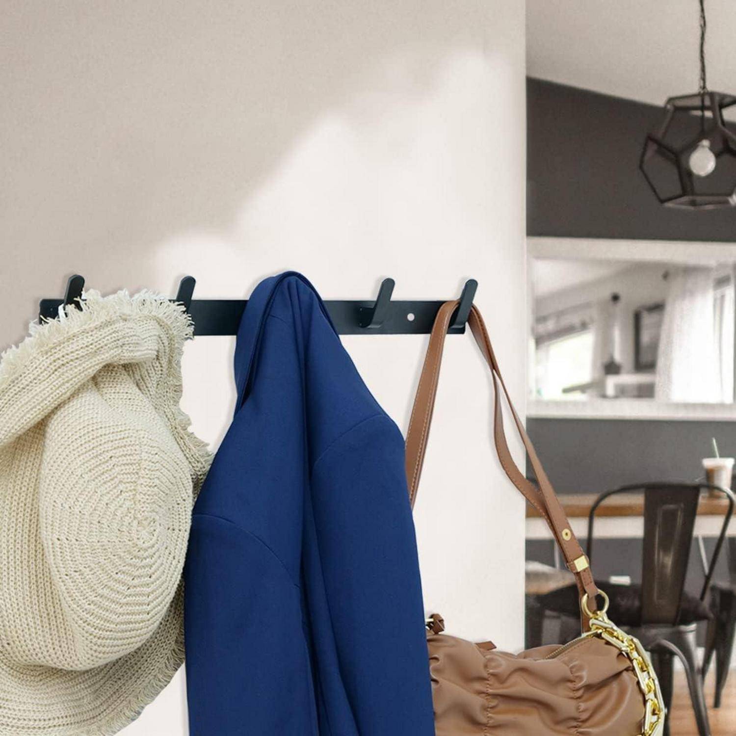 Garderobe mit einem Strohhut, blauer Jacke und brauner Handtasche in einem modernen Raum mit einem Essbereich im Hintergrund.