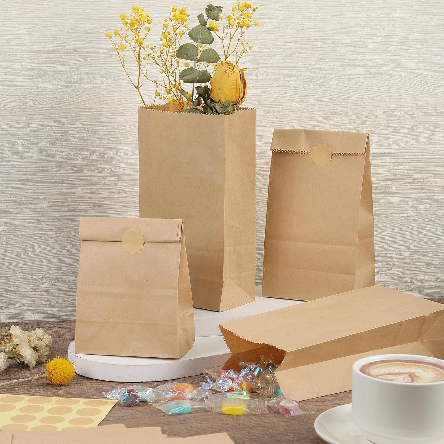 Ein Tisch mit braunen Papiertüten, einer Tasse Kaffee, lebhaften Blumen und bunten Süßigkeiten, der eine gemütliche, einladende Atmosphäre schafft.