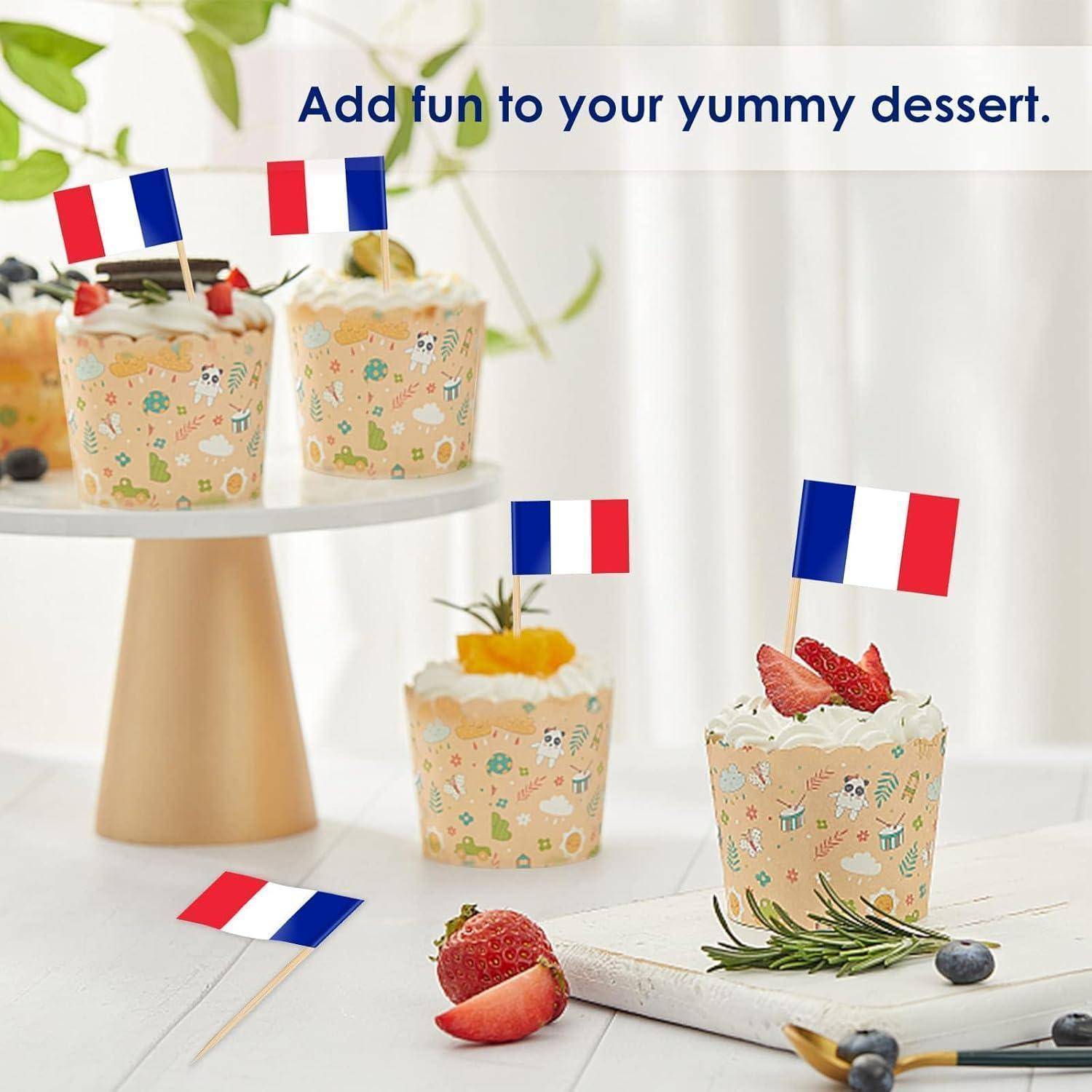Cupcakes mit kleinen französischen Flaggen als Verzierung, einige auf einem Kuchenständer. Text lautet: 