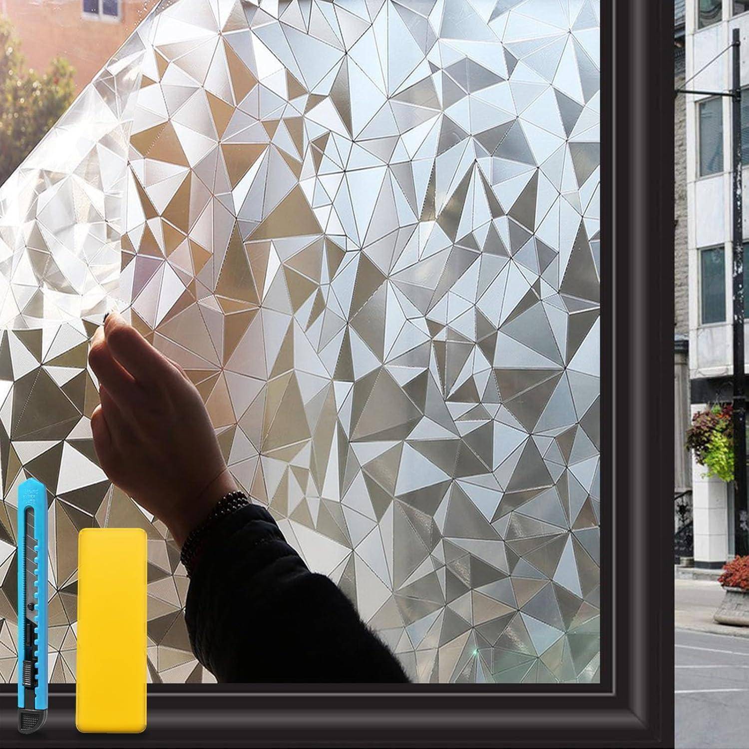 Eine Person bringt eine dekorative, geometrisch gemusterte Fensterfolie auf einer Scheibe an. Ein Rakel und ein Cuttermesser liegen auf dem Fenstersims draußen.