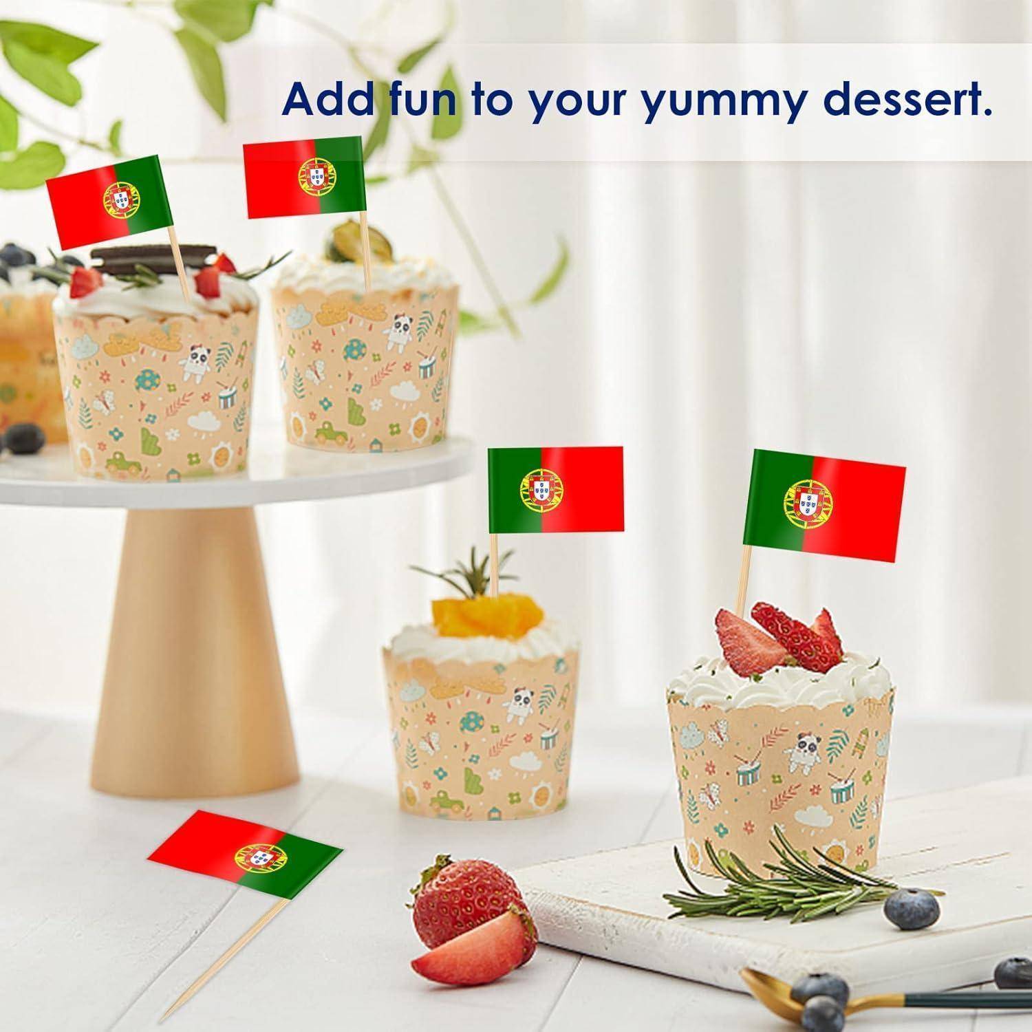 Cupcakes, die mit kleinen portugiesischen Flaggen dekoriert sind, auf einem Tisch mit Obst, begleitet von dem Text 