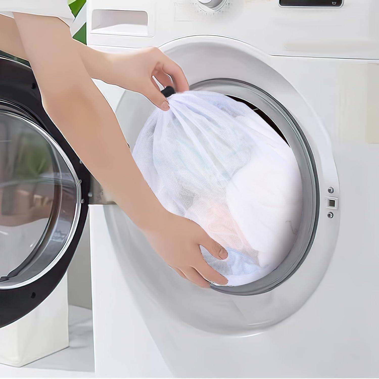 Eine Person lädt eine Waschmaschine mit Wäsche in einem Netzbeutel und deutet damit auf eine behutsame Wäsche von empfindlichen Kleidungsstücken hin.