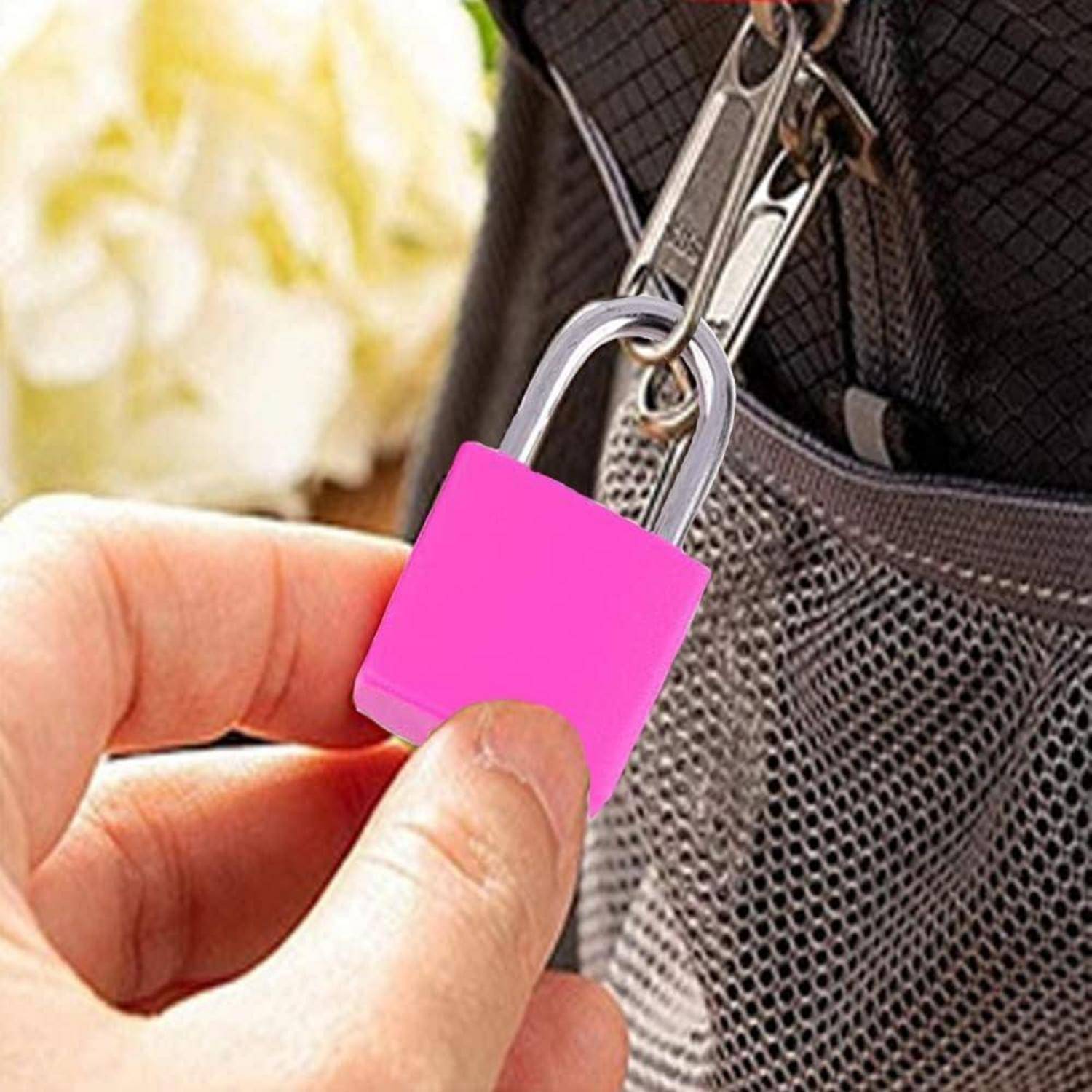 Eine Hand schließt ein rosa Vorhängeschloss an einem Rucksack, was Sicherheit oder Privatsphäre andeutet.