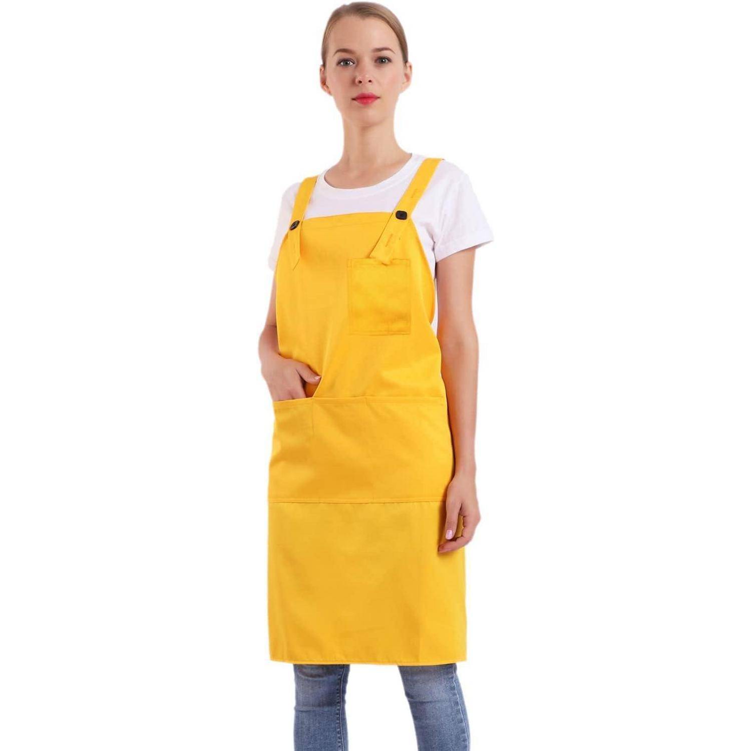 Eine Person trägt eine gelbe Schürze über einem weißen Hemd und Jeans und steht nach vorne gerichtet.