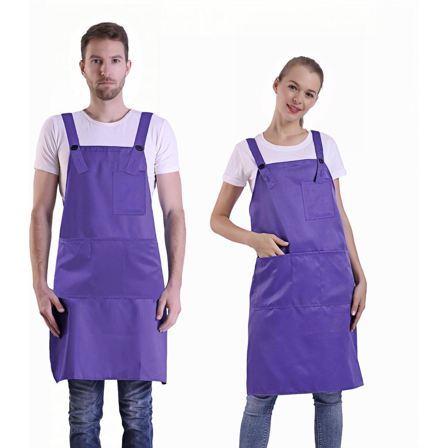Ein Mann und eine Frau in lila Schürzen und weißen T-Shirts stehen nebeneinander und blicken nach vorne. Die Frau hat ihre Hand in die Hüfte gestützt.