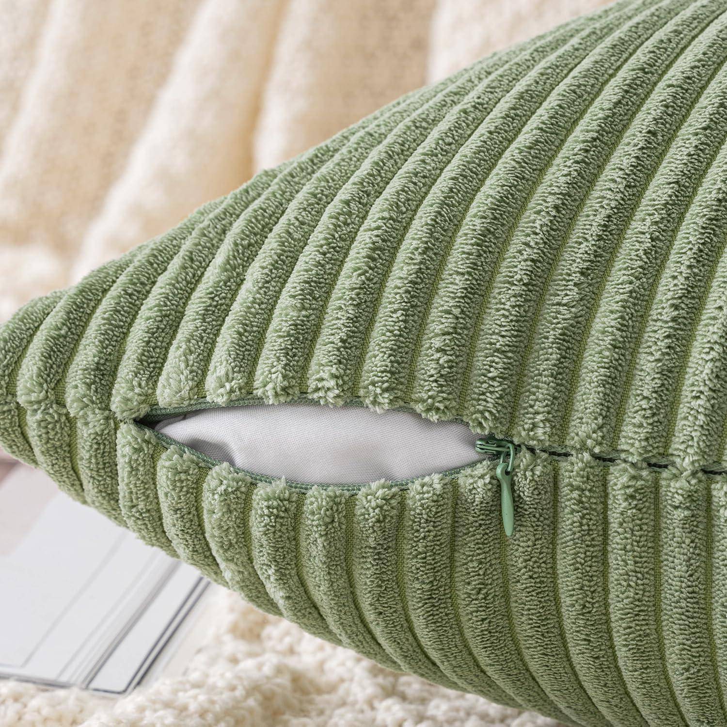 Ein grünes, geripptes Kissen mit sichtbarem, geöffnetem Reißverschluss, der das weiße Innere zeigt. Der Hintergrund ist eine weiche, beige strukturierte Oberfläche.