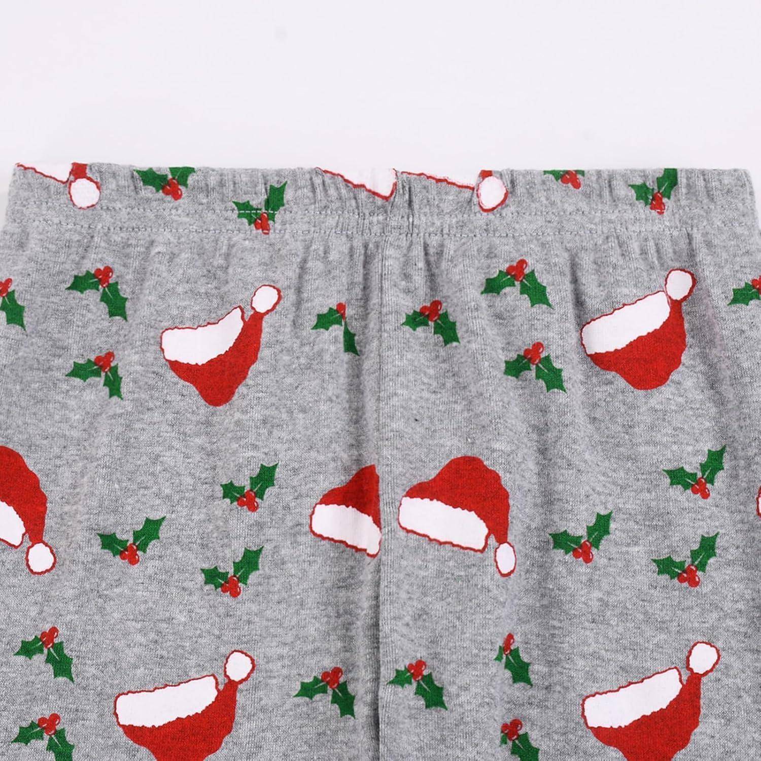 Grauer Stoff mit roten Weihnachtsmützen und grünen Stechpalmenmustern, die verstreut darauf verteilt sind.