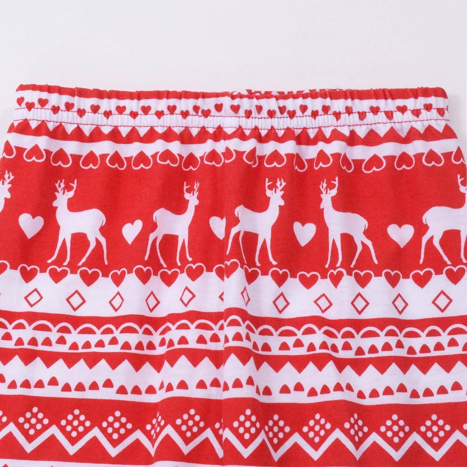 Eine rot-weiße Kurzhose mit einem Muster, das Rentiere, Herzen und geometrische Formen zeigt und einen festlichen oder weihnachtlichen Charakter andeutet.