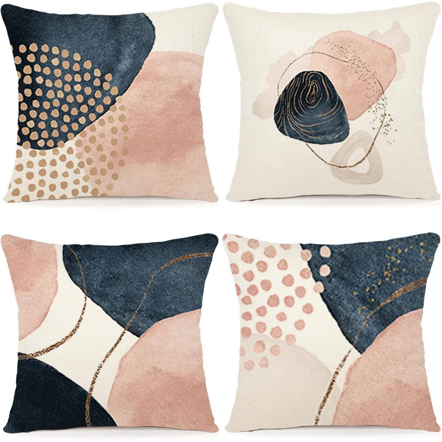 Vier dekorative Kissen mit abstrakten Mustern in Navy-Blau, Blush und Beige, die Kreise, Punkte und Pinselstriche zeigen.