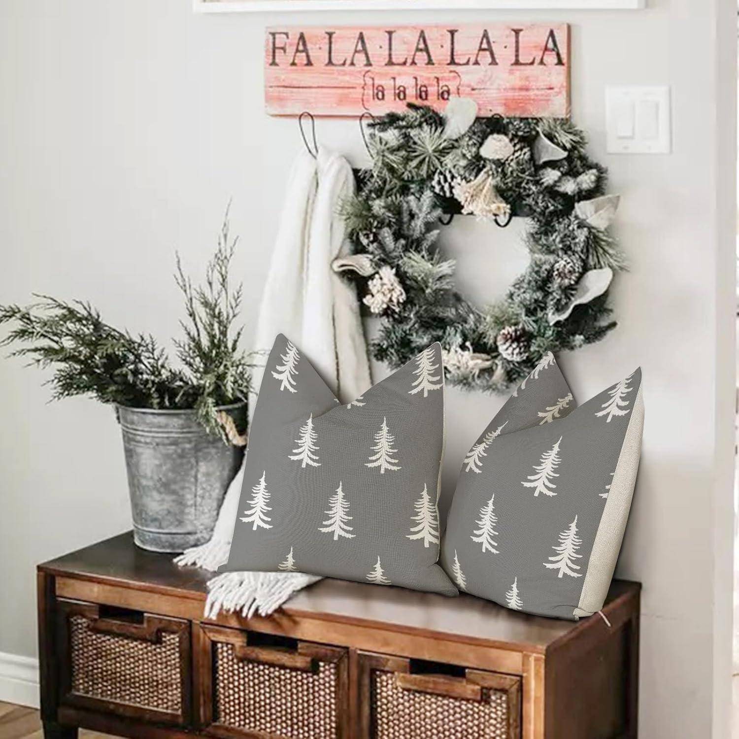 Eine gemütliche, weihnachtlich gestaltete Ecke im Wohnzimmer mit einem Kranz, Kissen mit Tannenzweigmuster und einem dekorativen Schild an der Wand, auf dem 