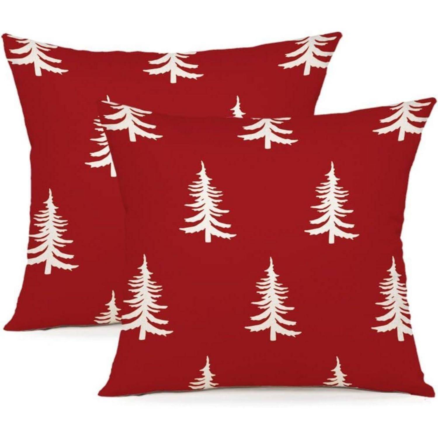 Zwei rote Kissenbezüge zeigen ein sich wiederholendes Muster von weißen Kiefern und gestalten so ein festliches, weihnachtlich geprägtes Design.