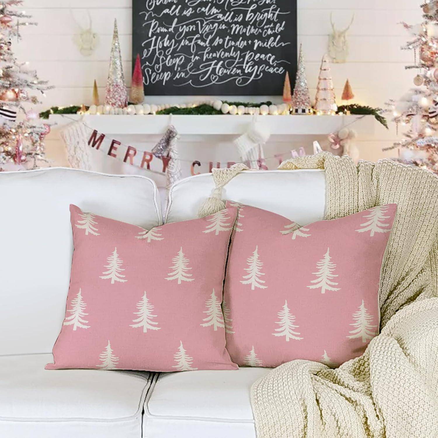Ein gemütliches, festliches Wohnzimmer mit einem weißen Sofa, rosa baumbemusterten Kissen, Weihnachtsdekoration und einem 