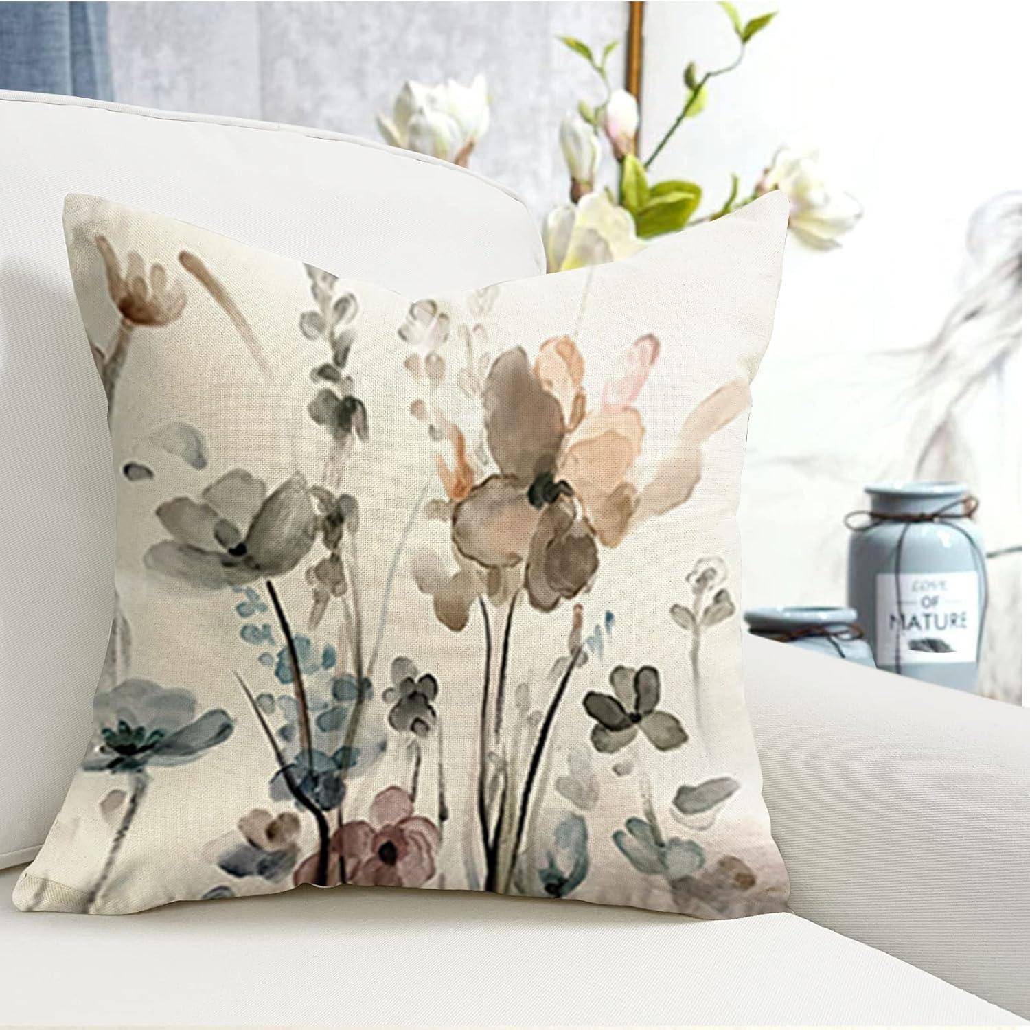 Ein Kissen mit Blumenmuster auf einem weißen Sessel, mit verschwommenen Blumen und Dekoration im Hintergrund. Gemütliche und stilvolle Einrichtung.
