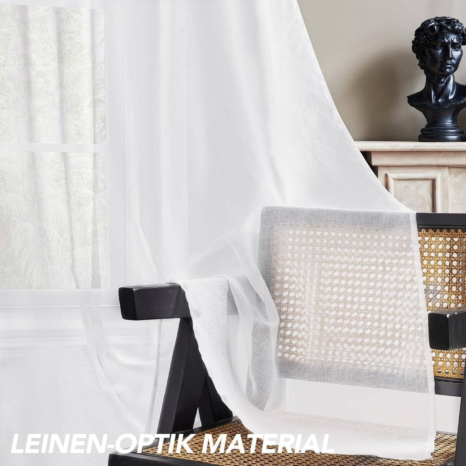 Ein Raum mit einem Fenster, das mit weißen Leinengardinen verhangen ist. Ein Stuhl mit geflochtenem Rücken steht daneben. Eine kleine Büste ist auf dem Schrank platziert.