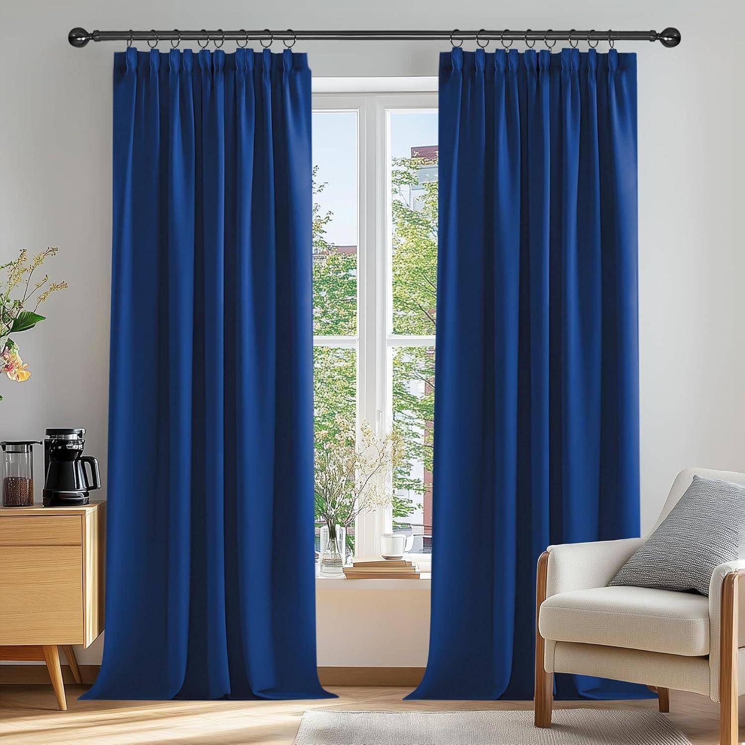 Ein Raum mit einem Fenster, das von blauen Vorhängen gerahmt wird, ein Stuhl auf der rechten Seite und ein kleiner Tisch mit einer Kaffeemaschine und einer Pflanze auf der linken Seite.
