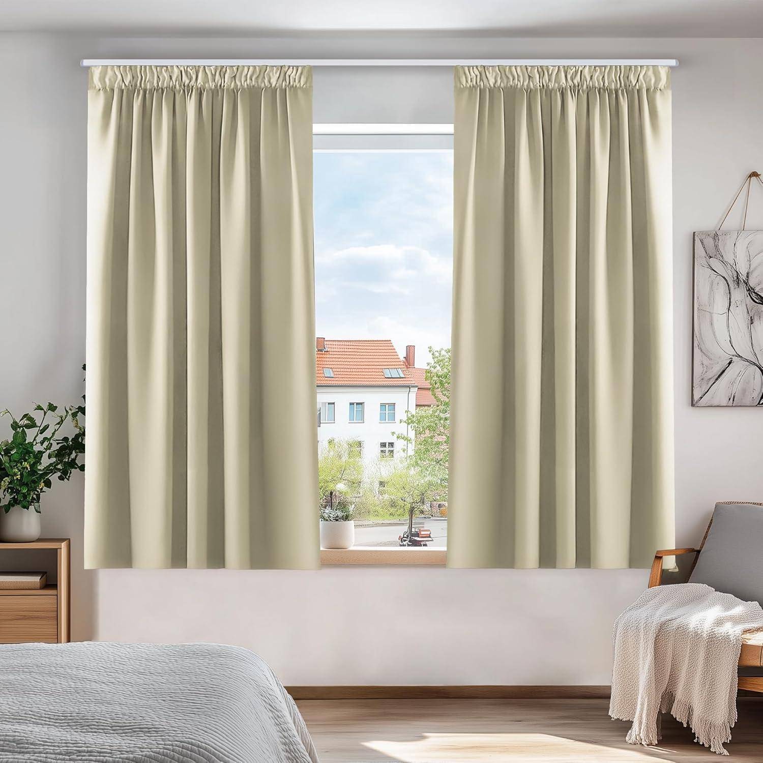 Ein sonnendurchfluteter Raum mit beigen Vorhängen, die teilweise geöffnet sind und den Blick auf ein Gebäude mit rotem Dach und Bäumen freigeben, gerahmt von weißen Wänden.