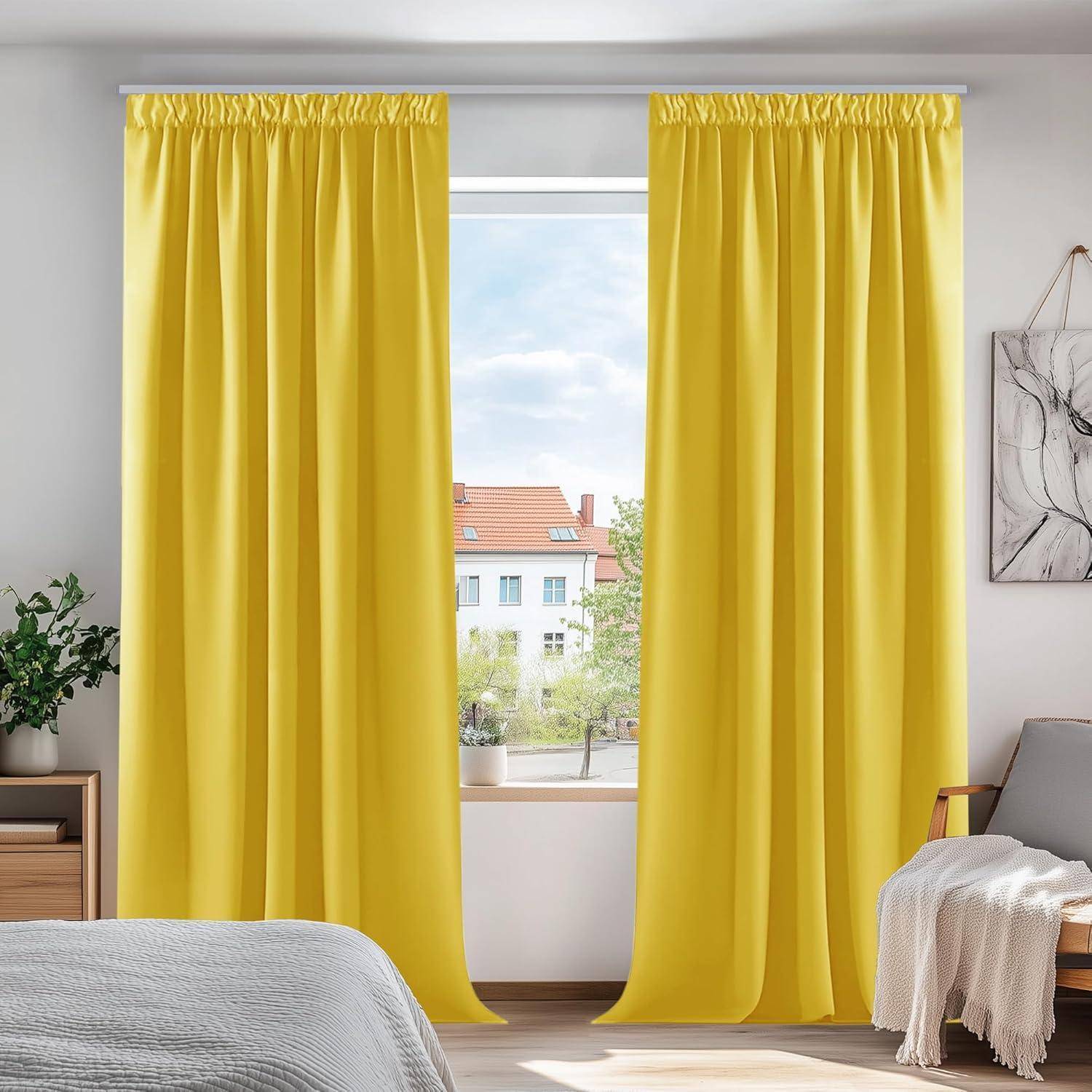 Raum mit einem Fenster, das von gelben Vorhängen gerahmt wird, mit Blick auf Gebäude. Ein Bett und eine kleine Pflanze befinden sich im Vordergrund.