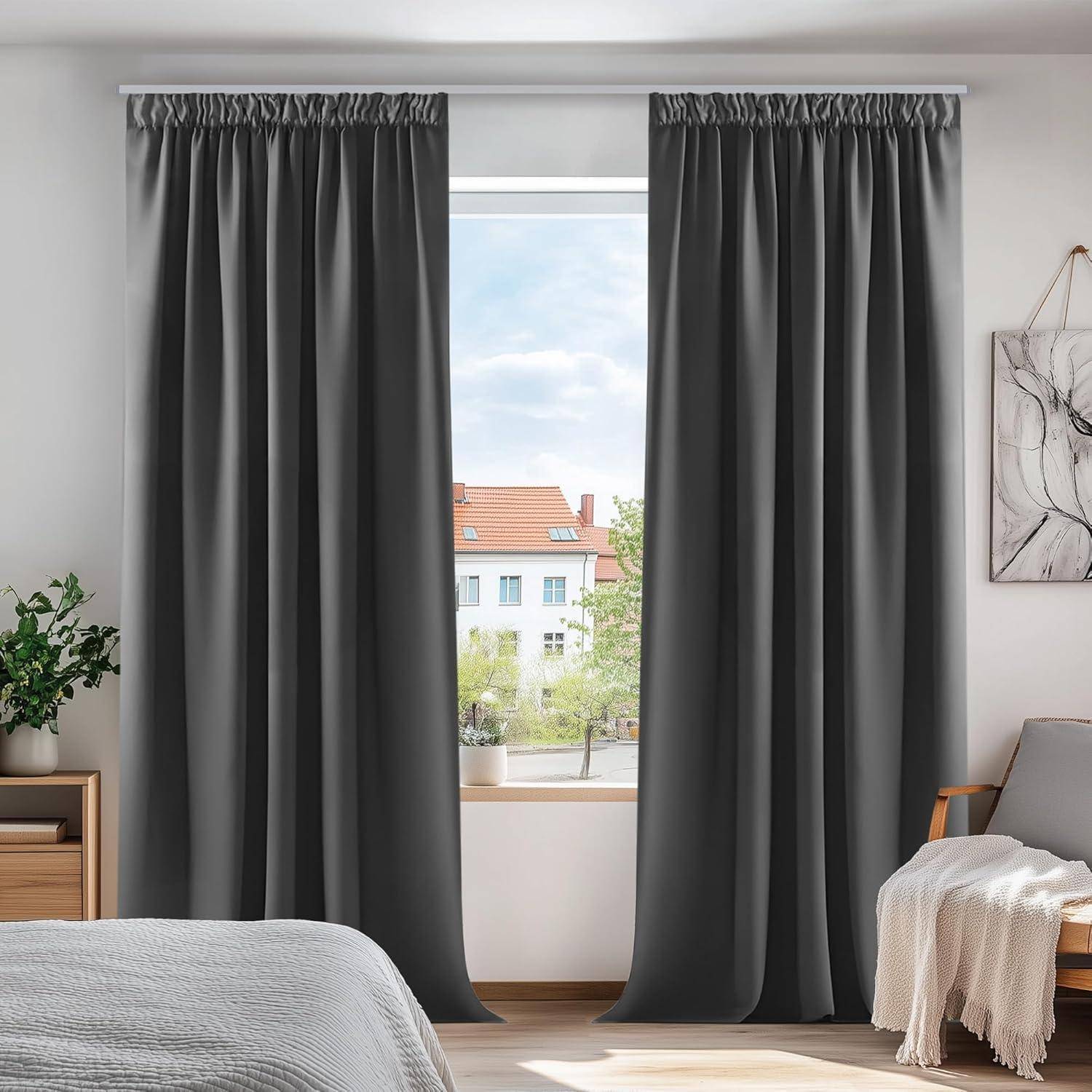 Ein heller Schlafzimmer mit einem großen Fenster, an dem graue Vorhänge hängen und natürliches Licht den Raum erhellen. Ein Bett und eine Pflanze sind zu sehen.