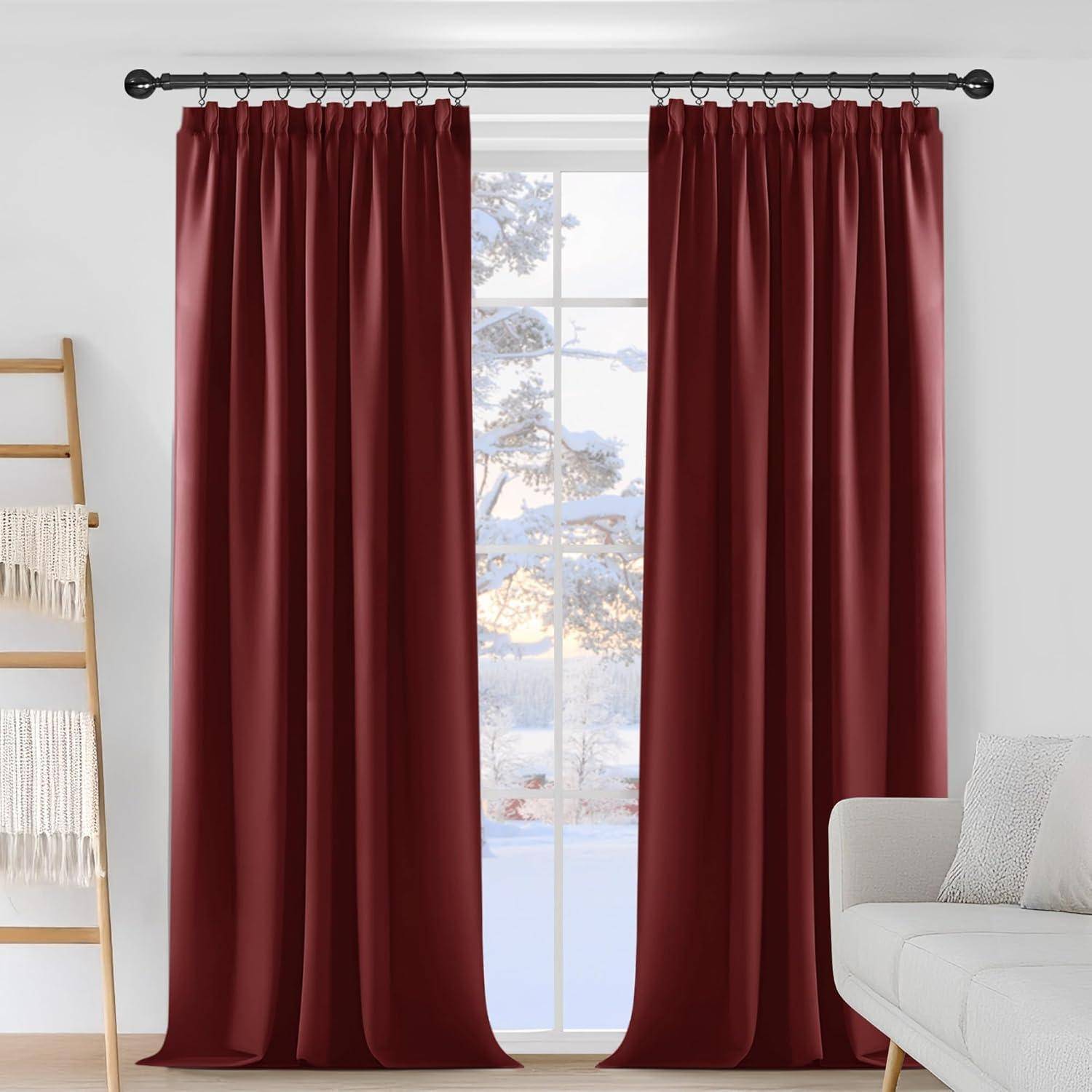 Rote Vorhänge hängen von einer schwarzen Stange und verdecken teilweise ein Fenster. Draußen sind verschneite Bäume zu sehen. Ein weißer Stuhl und eine Deckenleiter befinden sich in der Nähe.