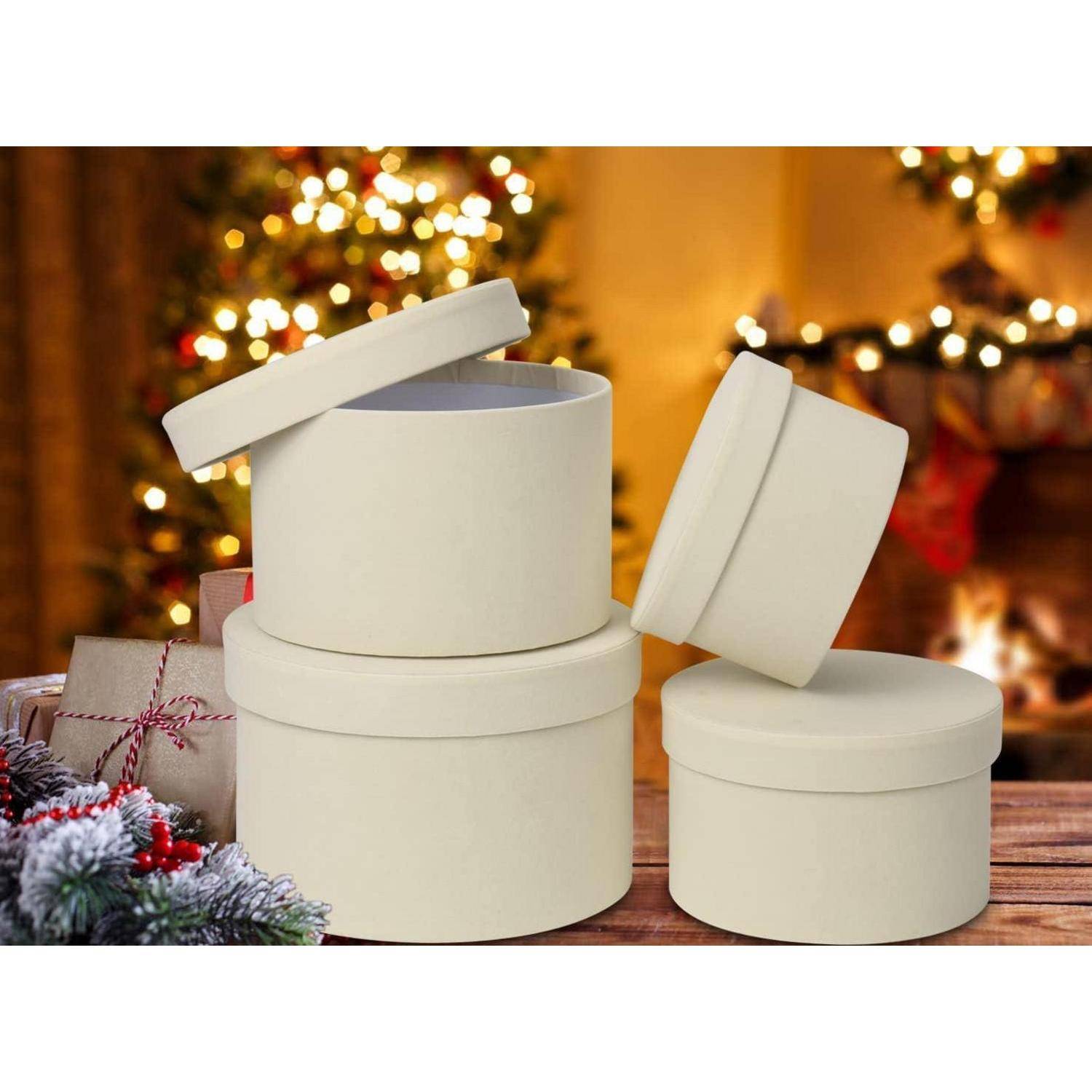 Cremefarbene Geschenkkartons mit Deckeln werden vor einem unscharfen Feiertagshintergrund mit geschmückten Weihnachtsbäumen präsentiert.