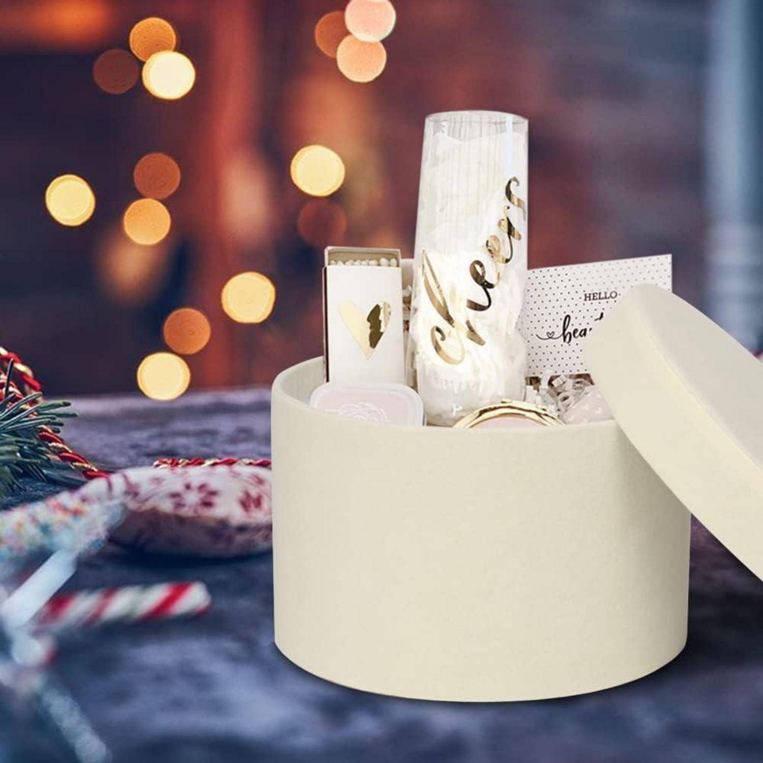 Eine Geschenkbox mit abgenommenem Deckel enthält einen Becher, auf dem 