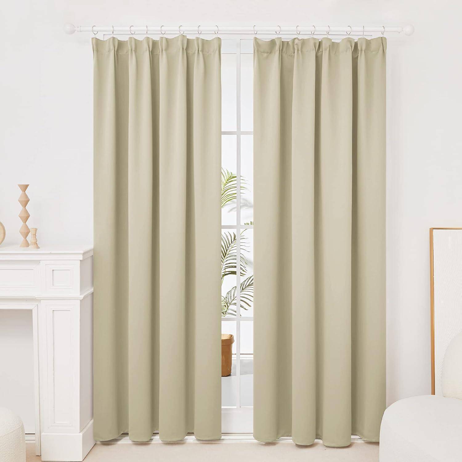 Ein Fenster mit beigen Vorhängen, die teilweise geöffnet sind, wobei Licht hindurchfiltert, und eine Pflanze ist verschwommen hinter dem Glas zu erkennen.