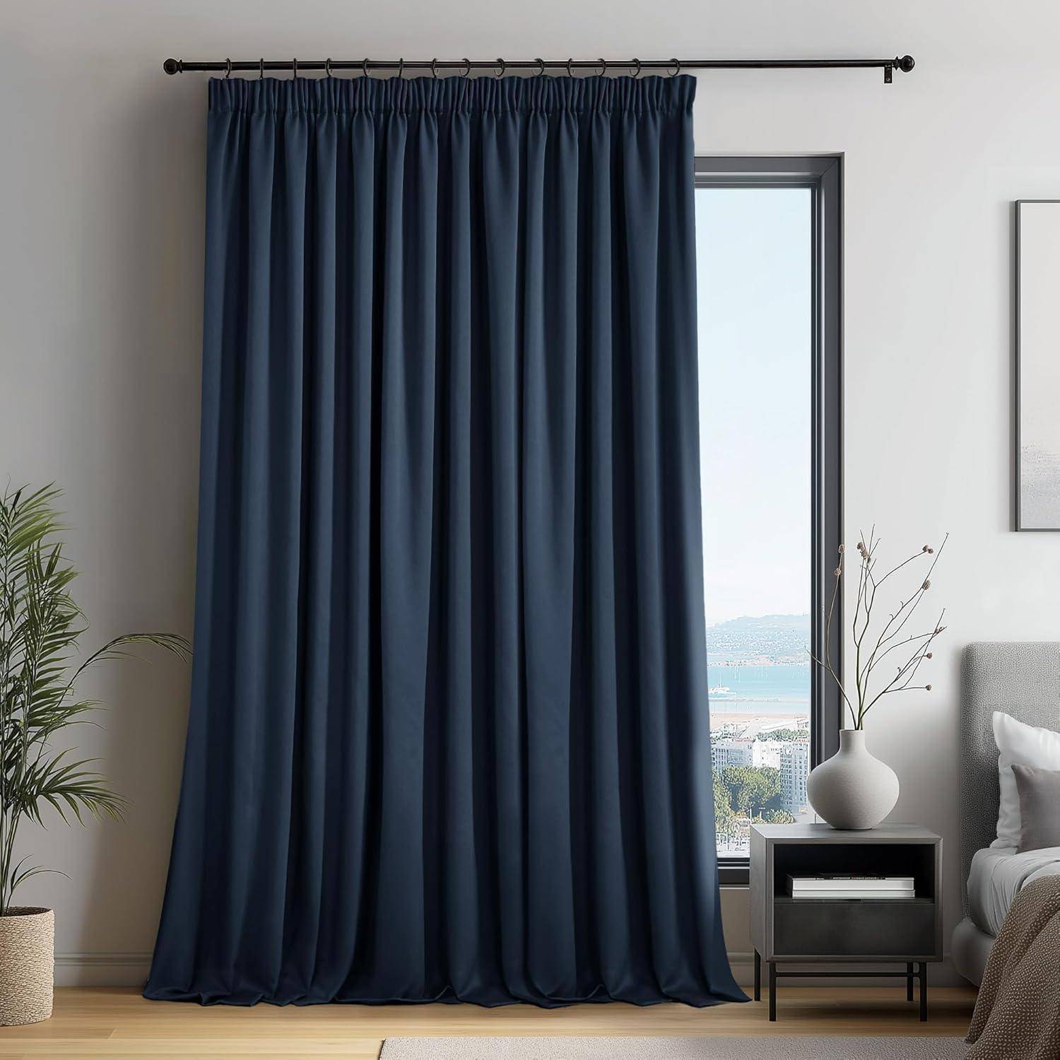 Ein dunkelblauer Vorhang hängt in einem Wohnzimmer und verdeckt teilweise ein Fenster mit Blick auf eine Küstenlandschaft draußen.