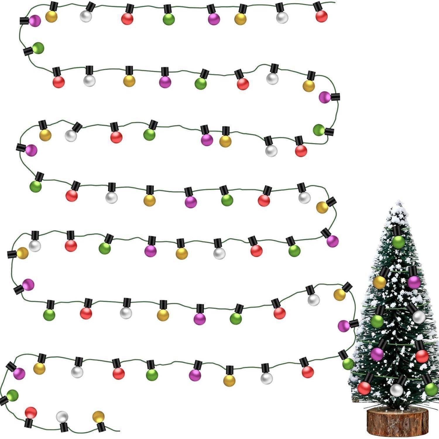 Bunte Lichterketten in Grün, Lila, Gelb, Silber und Rot, in mehreren Reihen ausgelegt. Rechts daneben ein kleiner geschmückter Weihnachtsbaum.