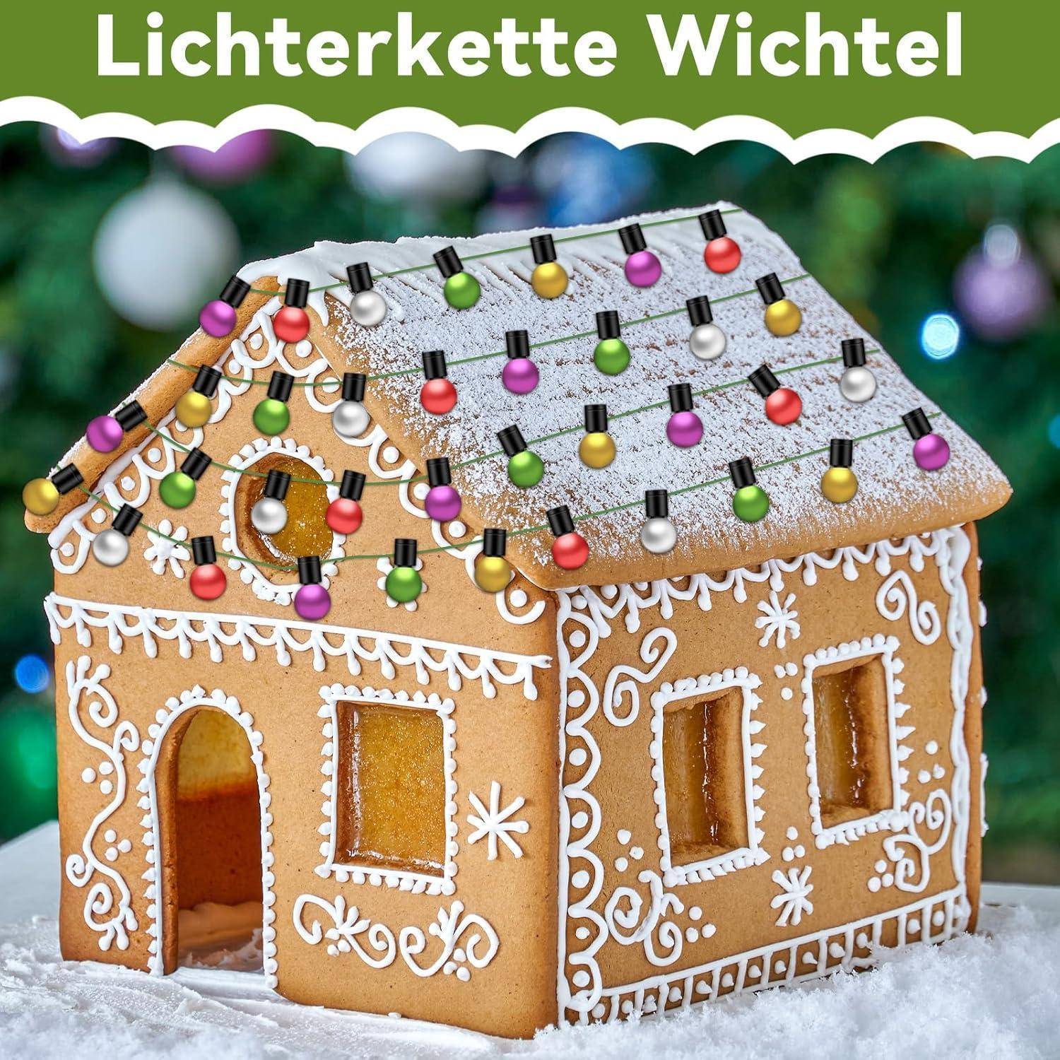 Lebkuchenhaus mit kunstvollen weißen Zuckergussmustern verziert, mit Zucker bestäubt und mit bunten Lichterketten geschmückt.