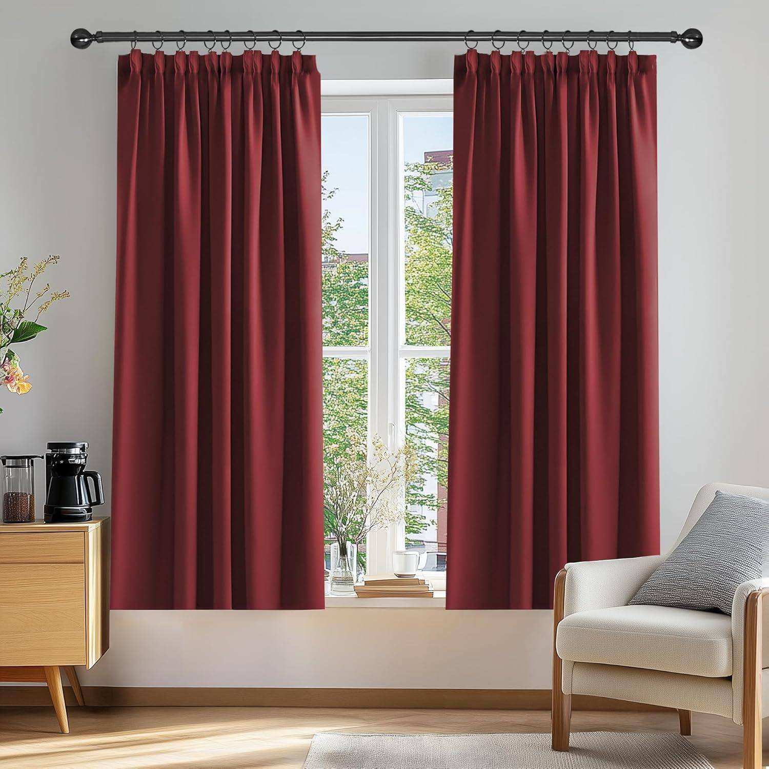 Ein Raum mit roten Vorhängen, die ein Fenster umrahmen, einem Holzschrank mit einer Kaffeemaschine links und einem beigen Sessel rechts.