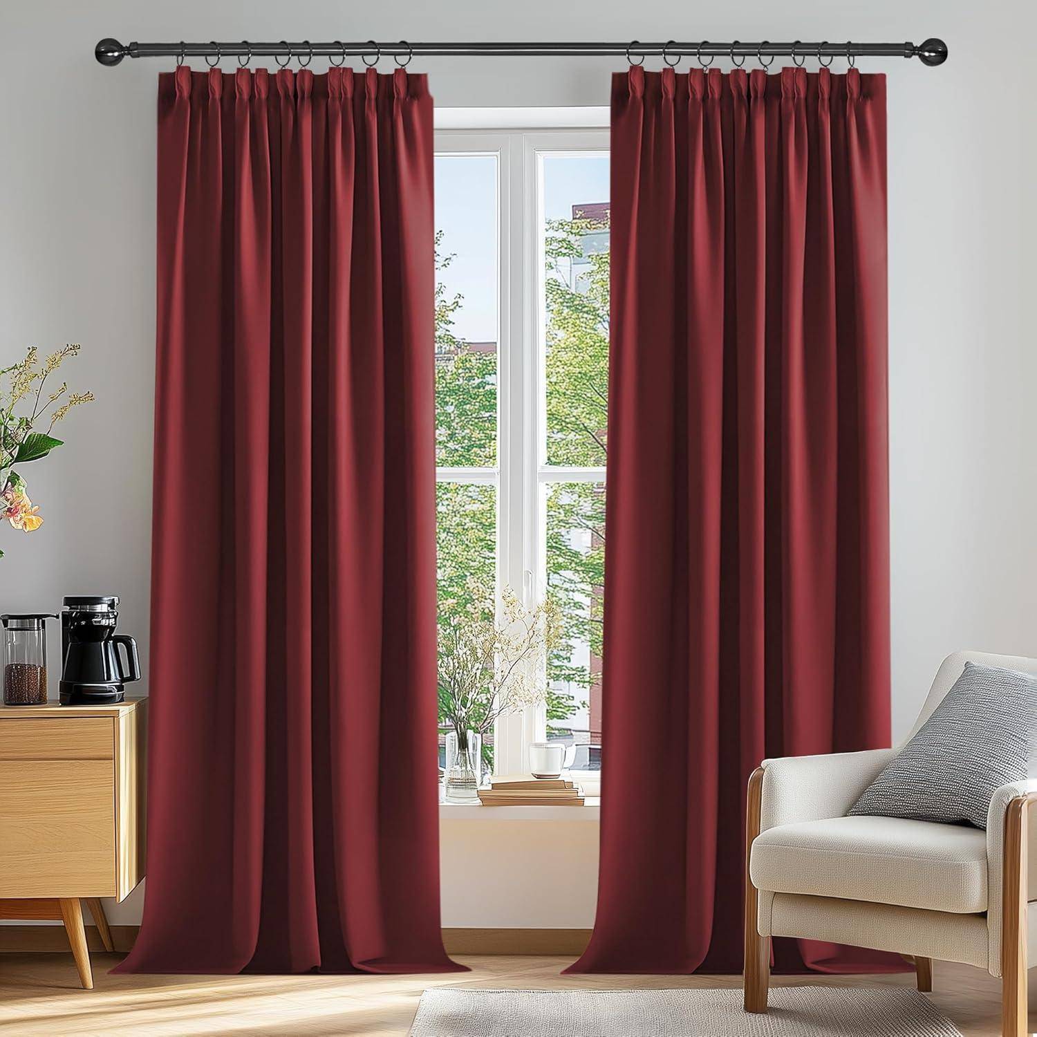 Rote Vorhänge rahmen ein sonnendurchflutetes Fenster mit Blick auf grüne Bäume. Ein beiger Stuhl und ein kleiner Tisch mit einer Kaffeemaschine befinden sich in der Nähe.