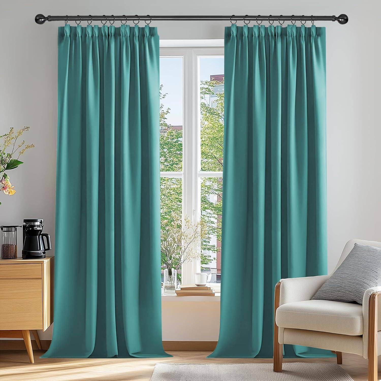 Ein Wohnzimmer mit einem großen Fenster, das von türkisfarbenen Vorhängen umrahmt wird. Ein Holzschrank mit einer Kaffeemaschine steht links, und ein weißer Stuhl rechts.