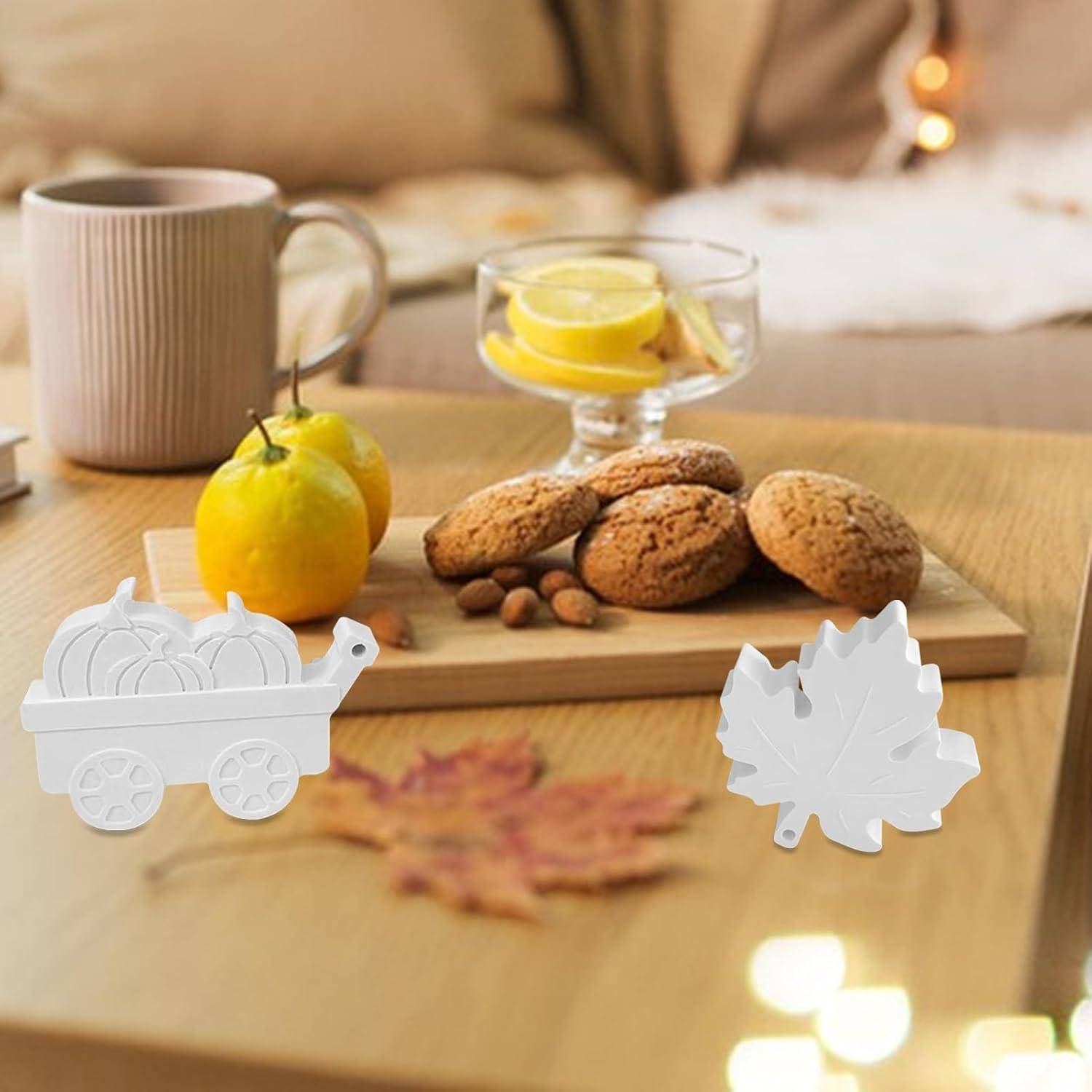 Eine gemütliche Atmosphäre mit einer grauen Tasse, einer Schüssel mit Keksen und Mandeln auf einem Holztisch. Zitronen auf dem Tisch und unscharfe Herbstblätter in der Nähe.