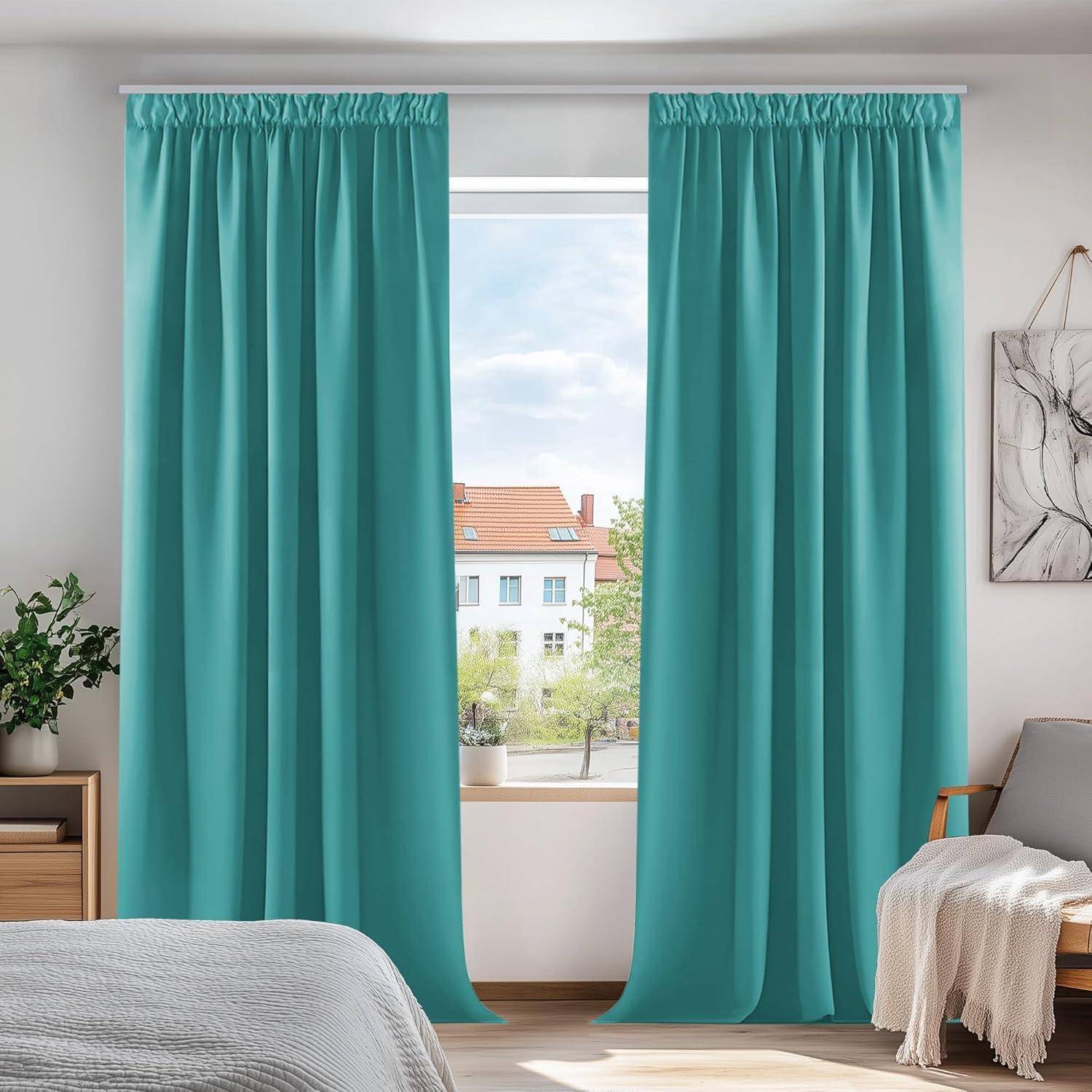 Ein Schlafzimmer mit einem Fenster, das von blauen Vorhängen gerahmt wird. Draußen ein Blick auf Häuser mit roten Dächern. Ein Bett und eine Pflanze befinden sich im Vordergrund.