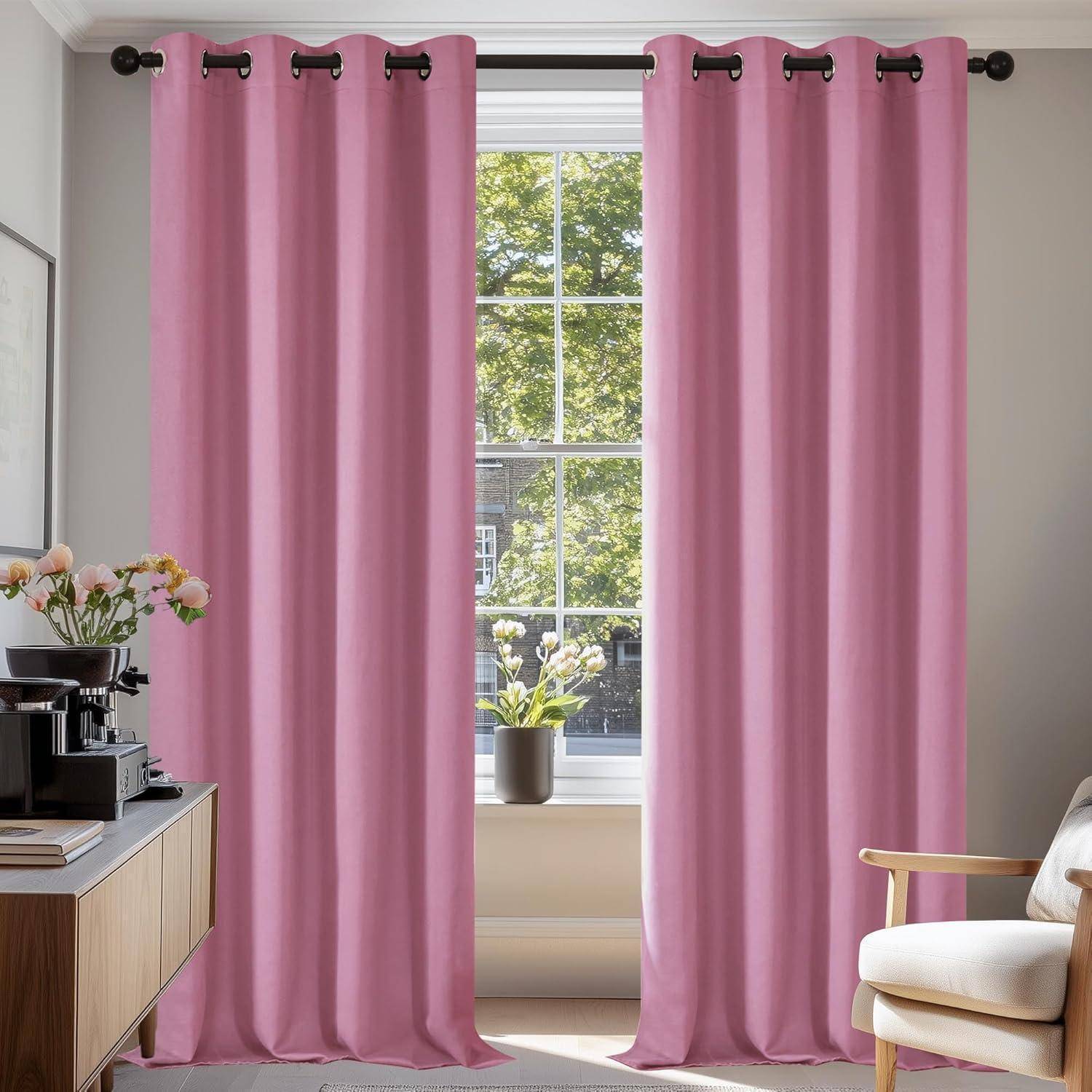Zwei rosa Vorhänge hängen an einem Fenster und rahmen den Blick auf einen grünen Baum im Freien. Auf dem Fenstersims steht eine Topfpflanze.
