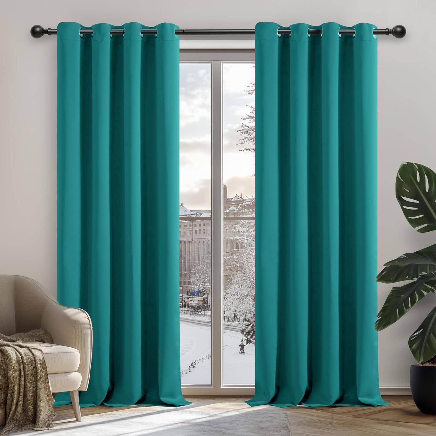 Ein großes Fenster mit blauen Vorhängen blickt auf eine verschneite Stadtlandschaft. Ein beiger Sessel mit einer darüber gelegten Decke steht links, und rechts befindet sich eine Pflanze.