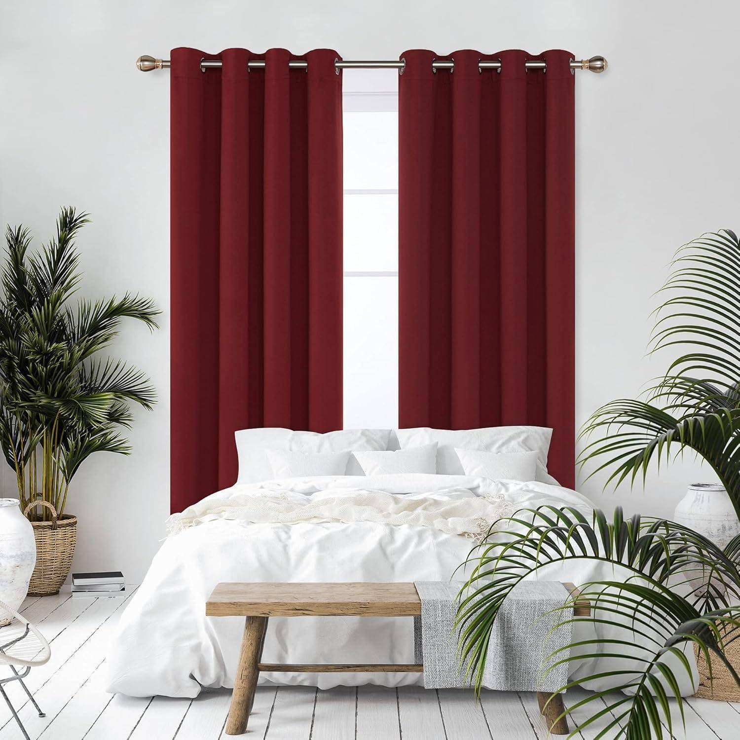 Ein Schlafzimmer mit einem weißen Bett, roten Vorhängen und mehreren Topfpflanzen vor einer weißen Wand, die eine gemütliche und einladende Atmosphäre schaffen.