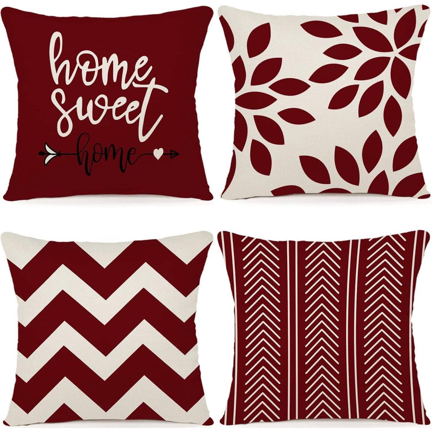 Vier dekorative Kissen mit roten und weißen Mustern. Oben links: 'home sweet home' Text; oben rechts: Blattdesign; unten links: Zickzack; unten rechts: Chevronstreifen.